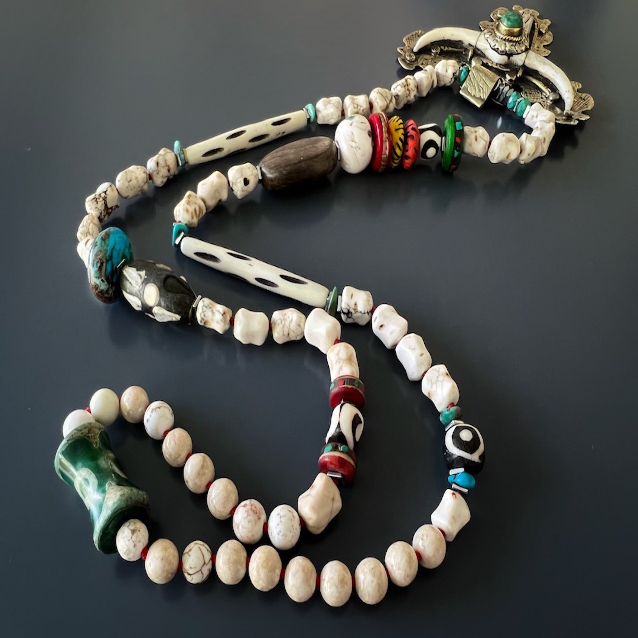 The necklace highlights the handmade carved longhorn pendant and the combination of white Tibetan, Agate, and natural turquoise beads, exuding a sense of spirituality and emotional balance.