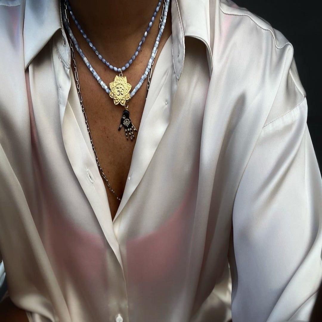 A different angle of the Grounding Necklace, highlighting the intricate details of the hand pendant. The model wearing the necklace demonstrates the versatility and style that the necklace brings to any outfit.