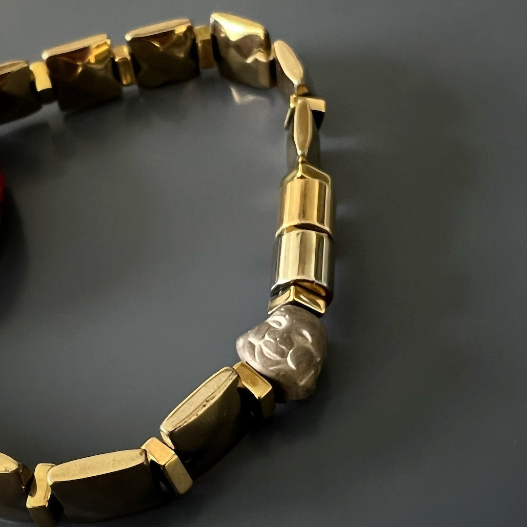 The Om Mani Padme Hum Coral Mantra Bracelet radiates spiritual energy and protection with its coral mantra bead and gold color hematite stones.