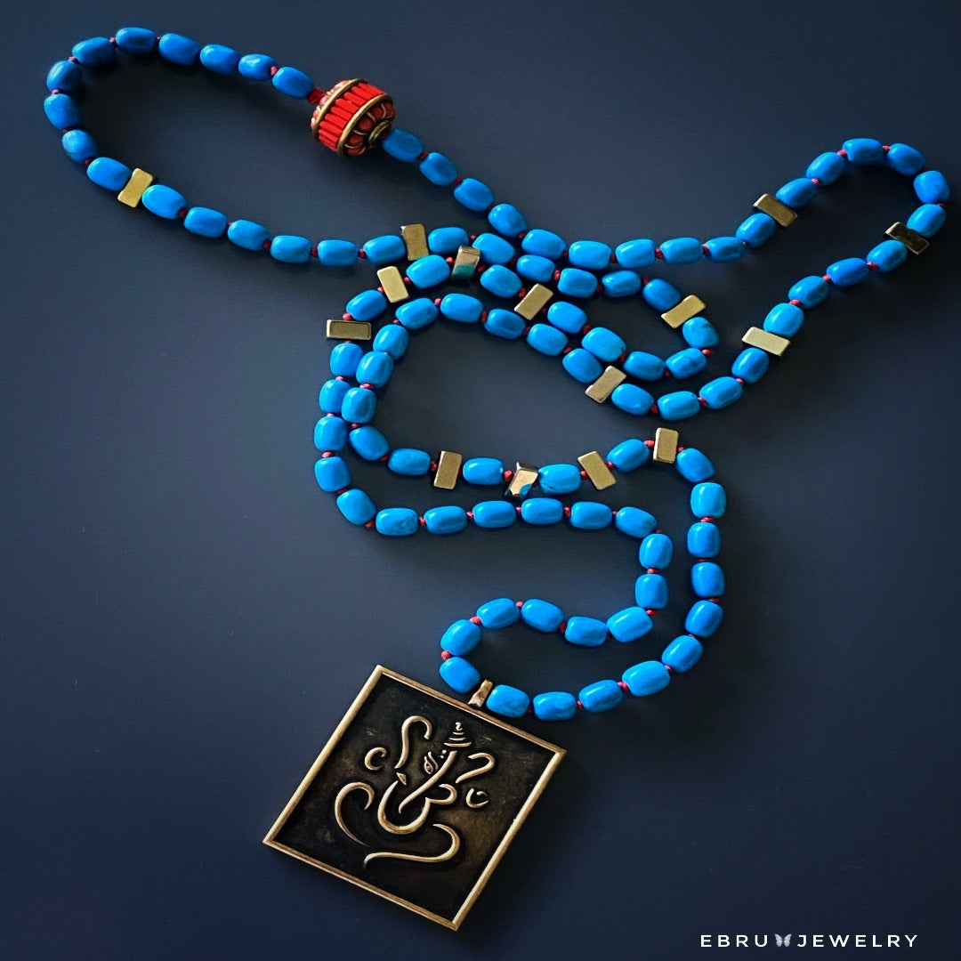 Handmade necklace featuring turquoise beads and a pendant representing positivity and spiritual teachings.