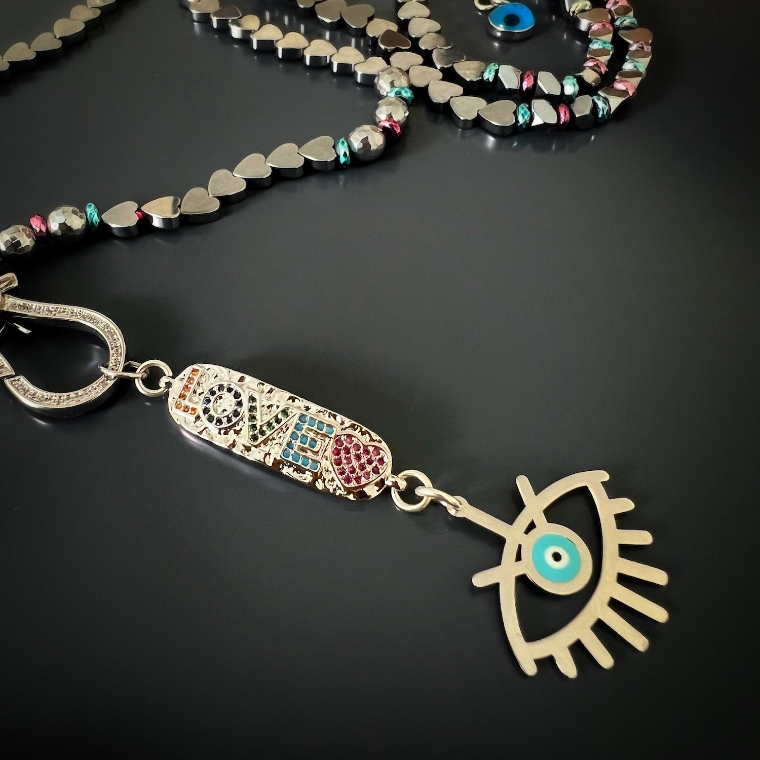 Necklace featuring silver heart beads and protective evil eye charm
