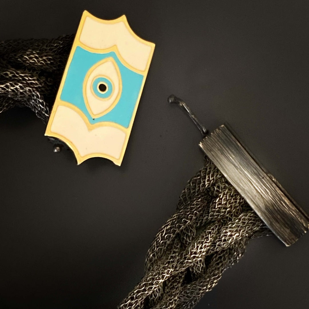 Discover the craftsmanship of the Silver Braided Evil Eye Bracelet, a handmade accessory that showcases attention to detail and symbolism.