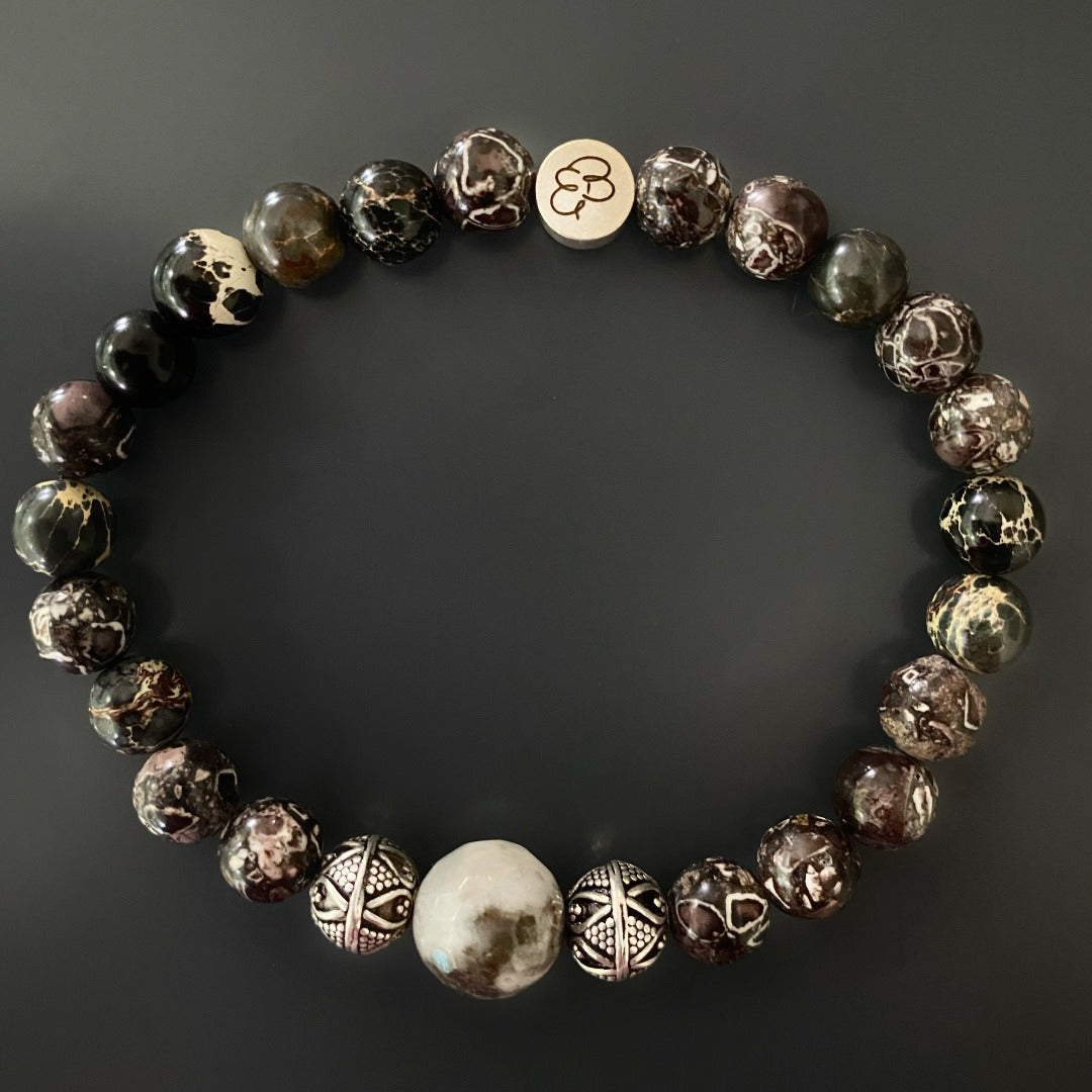 Close-up of handmade bracelet with earthy brown jasper, silver tribal accents, and agate focal.