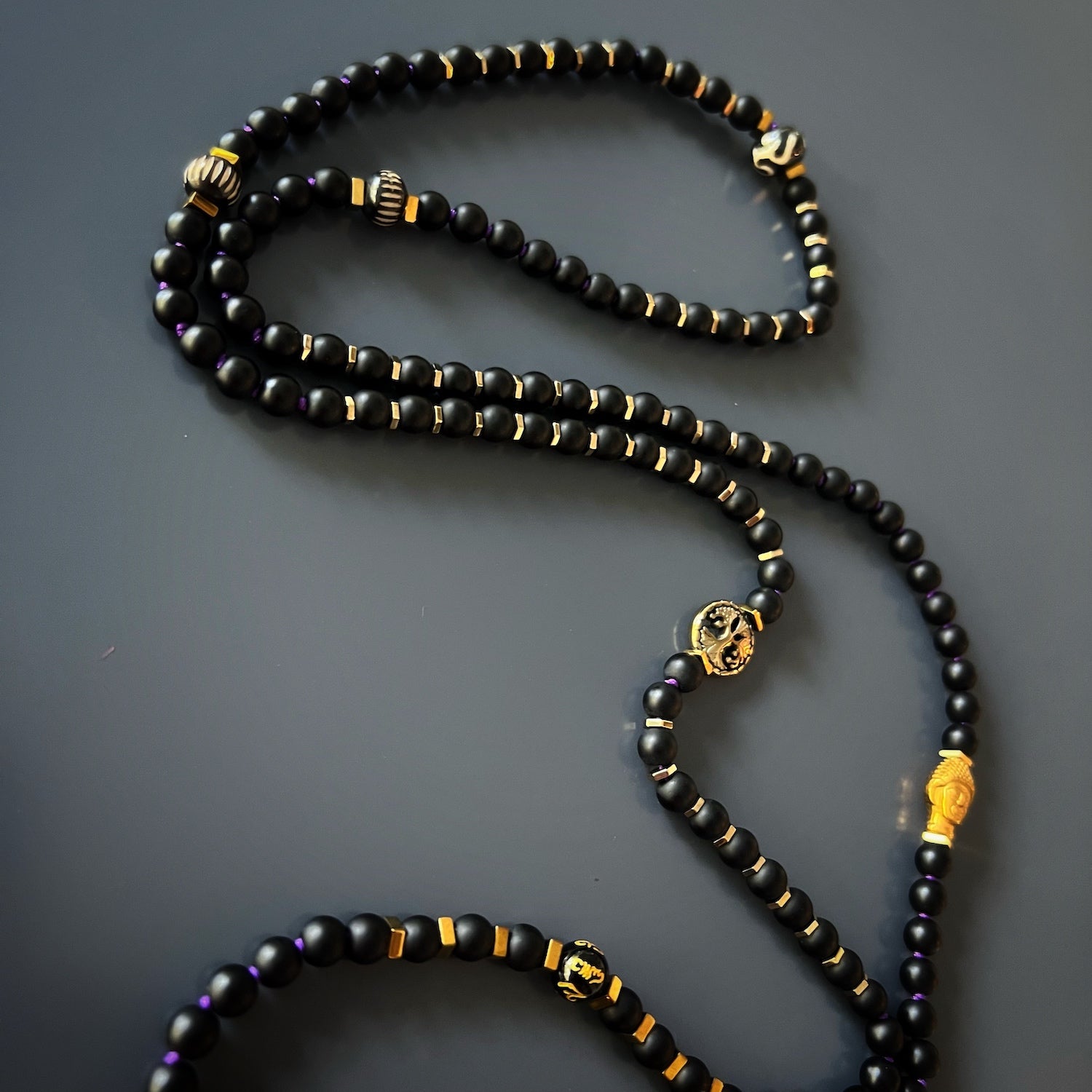 The gold color Buddha shape hematite stone beads in the Spiritual Yoga Mala Onyx Necklace
