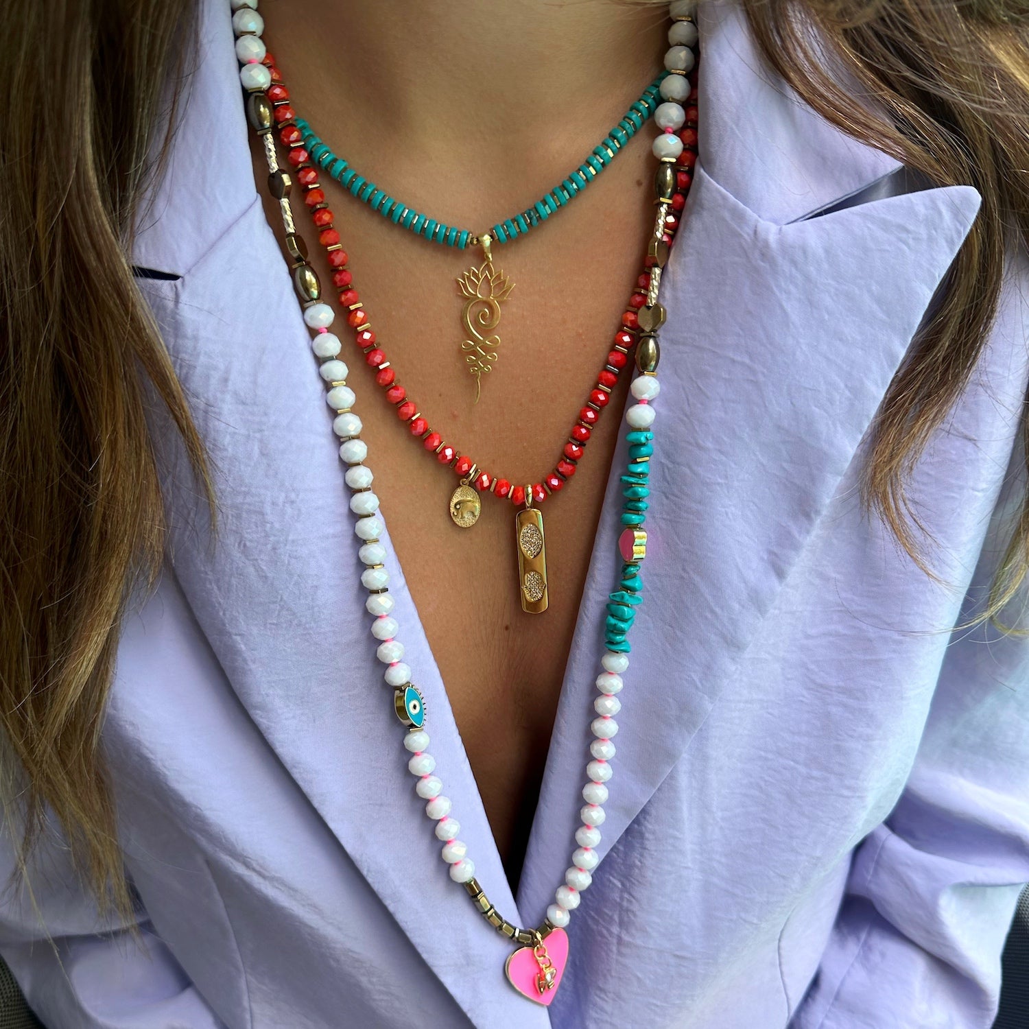 Model showcasing the handmade necklace adorned with a gold plated elephant charm and a meaningful Hamsa pendant