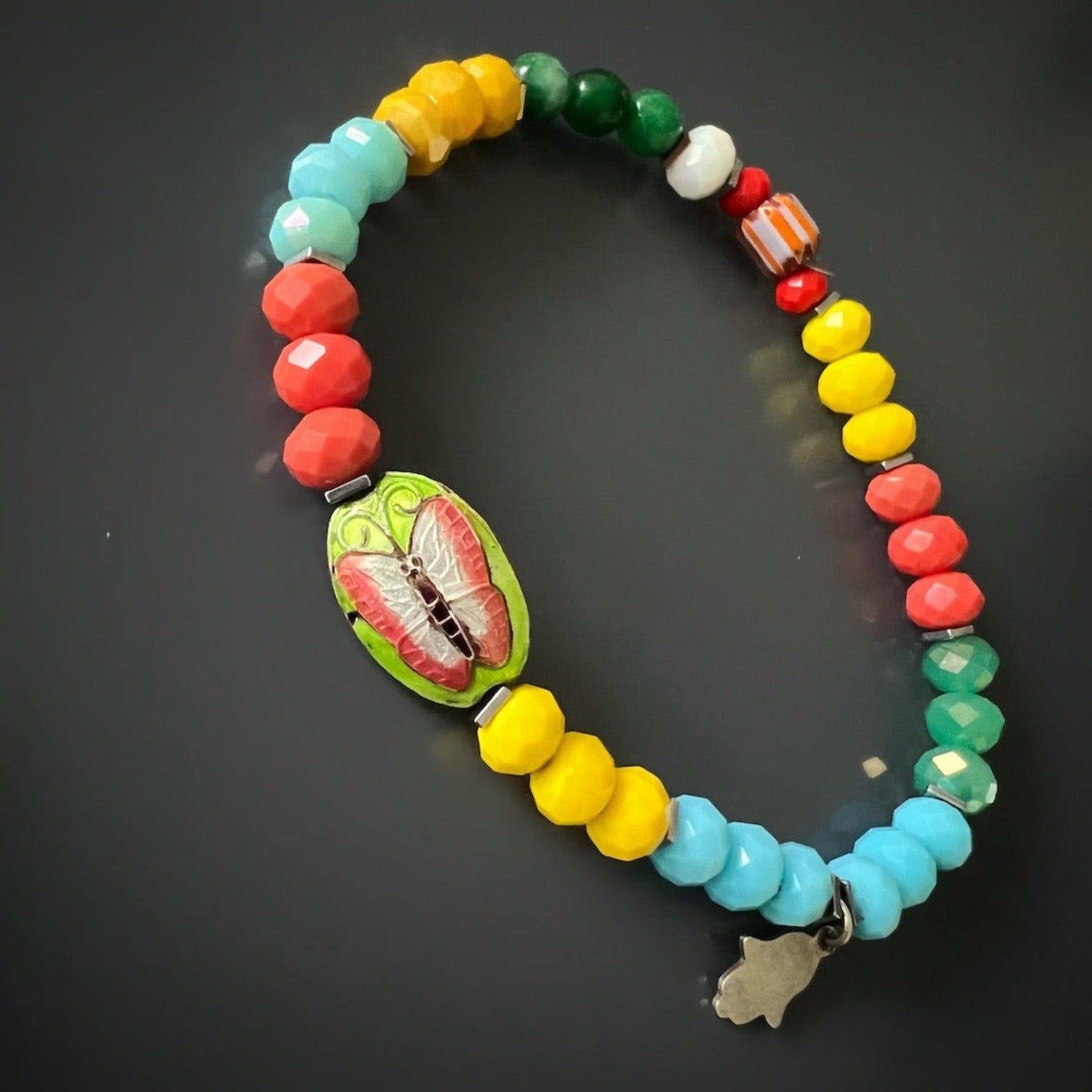 Handmade anklet blending protection and joy through Hamsa and butterfly.