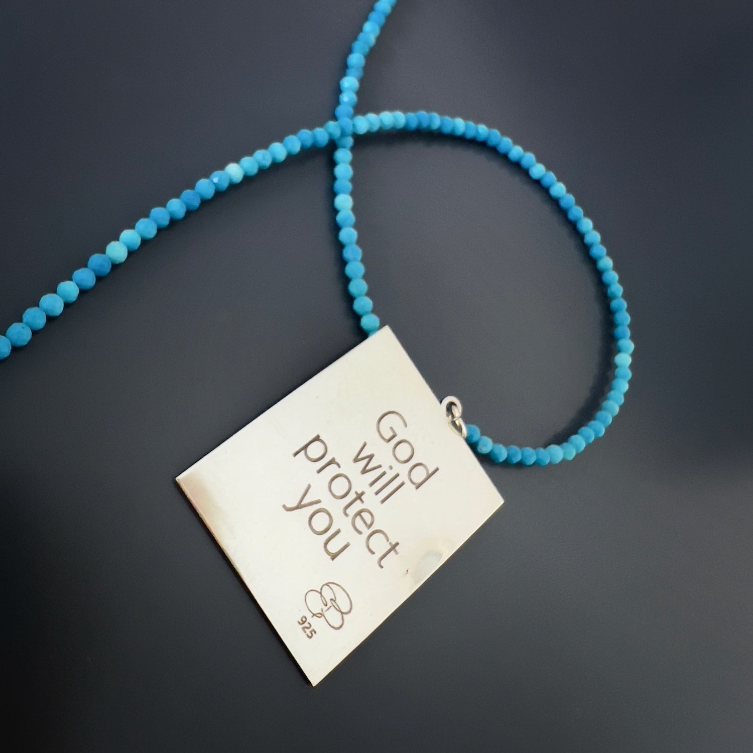 A detailed view of the meaningful inscription on the pendant of the Turquoise Necklace