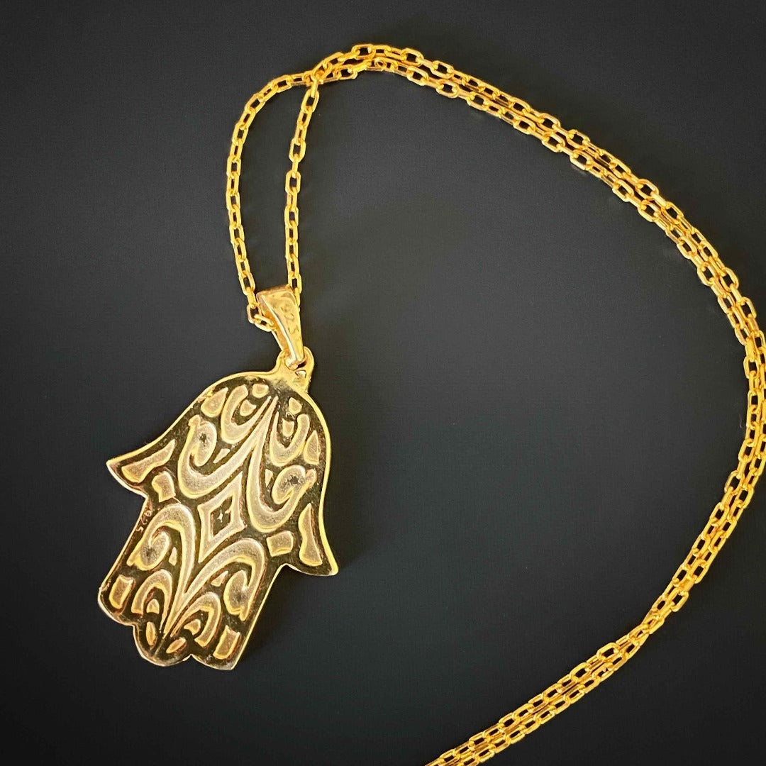 Experience the elegance and spiritual significance of the Stay Positive Hamsa Necklace, showcasing a beautiful hamsa pendant made of sterling silver and 18K gold plating with colorful enamel accents.