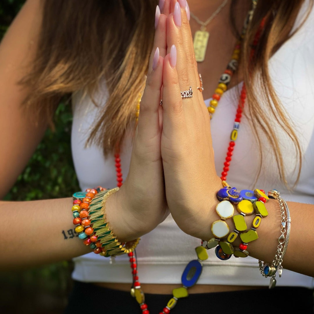 The Unique African Bracelet Set enhances the hand model's style, showcasing its vibrant beads and cultural significance.