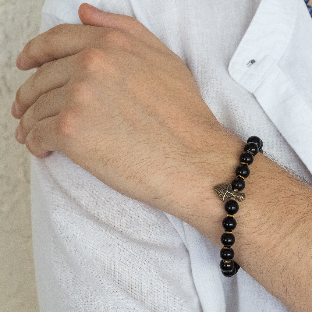 Handmade bracelet featuring 8mm black onyx beads, bronze bead, and arrowhead centerpiece.