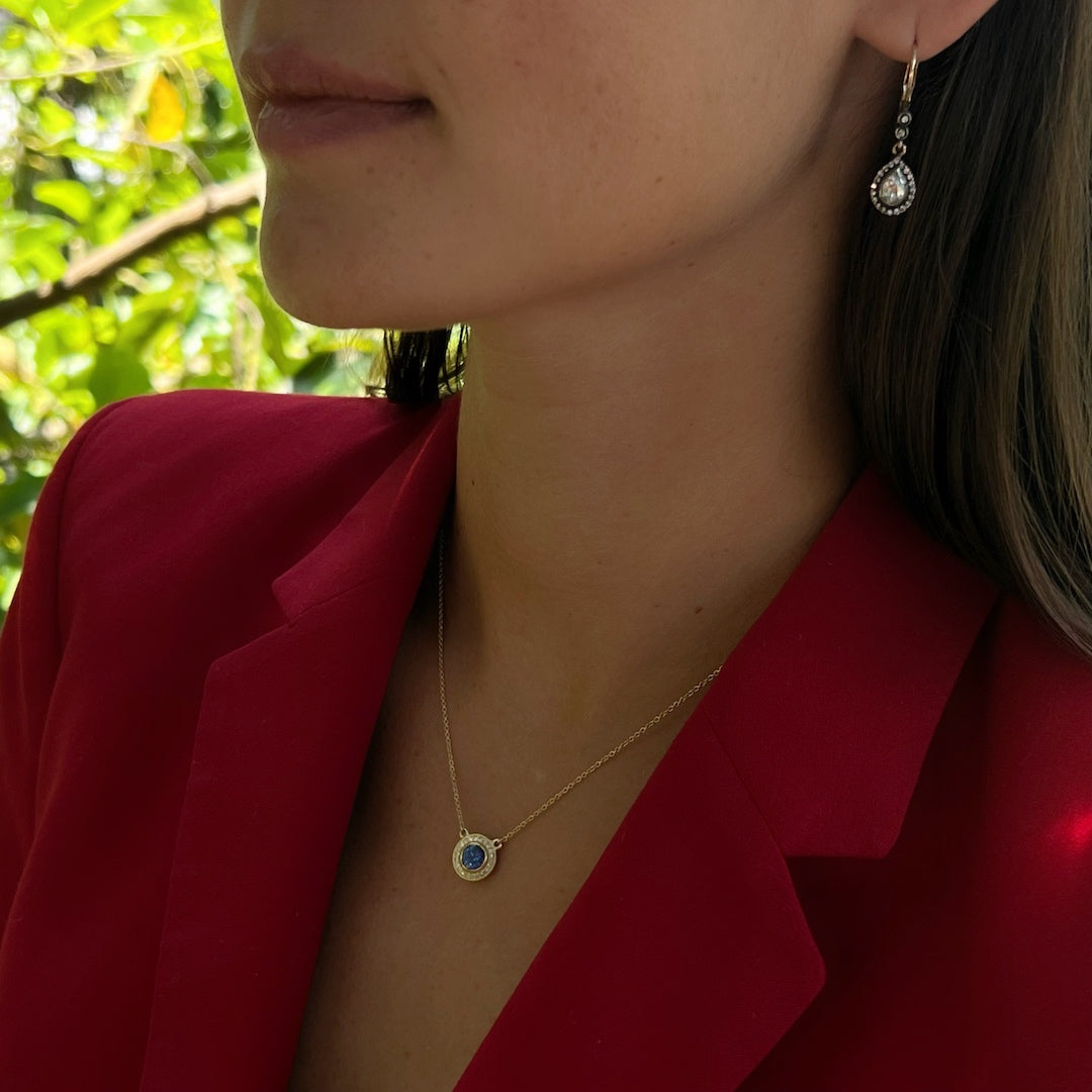 Close-up of a model wearing the Elegant Sapphire Necklace, highlighting the intricate details of the handcrafted pendant and the brilliance of the sapphire and diamonds.