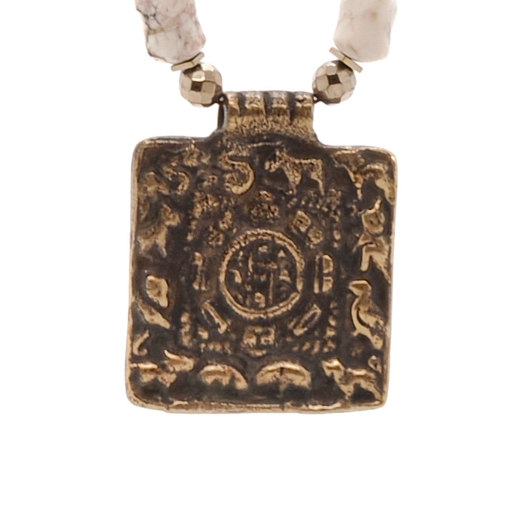 Handmade Nepal Om Necklace - A close-up of the intricate details of the Ethnic Nepal Om Necklace. The combination of brown natural wood beads, colorful African beads, and the brass square Om Mantra pendant creates a visually captivating design.