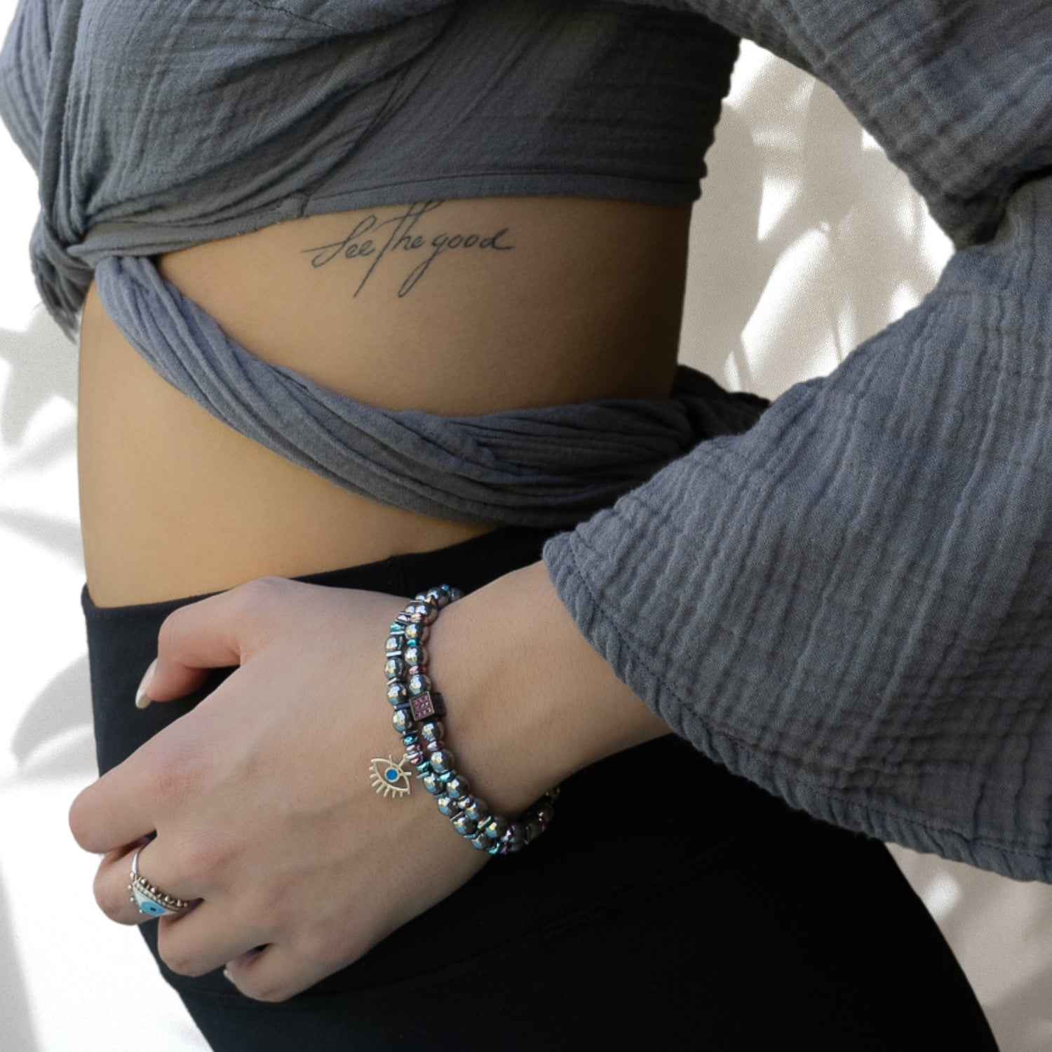 Model wearing Eye Protection Hematite Bracelet Set - Handcrafted jewelry featuring silver hematite beads, Evil Eye charms, and a Swarovski crystal bead, showcasing style and protection.