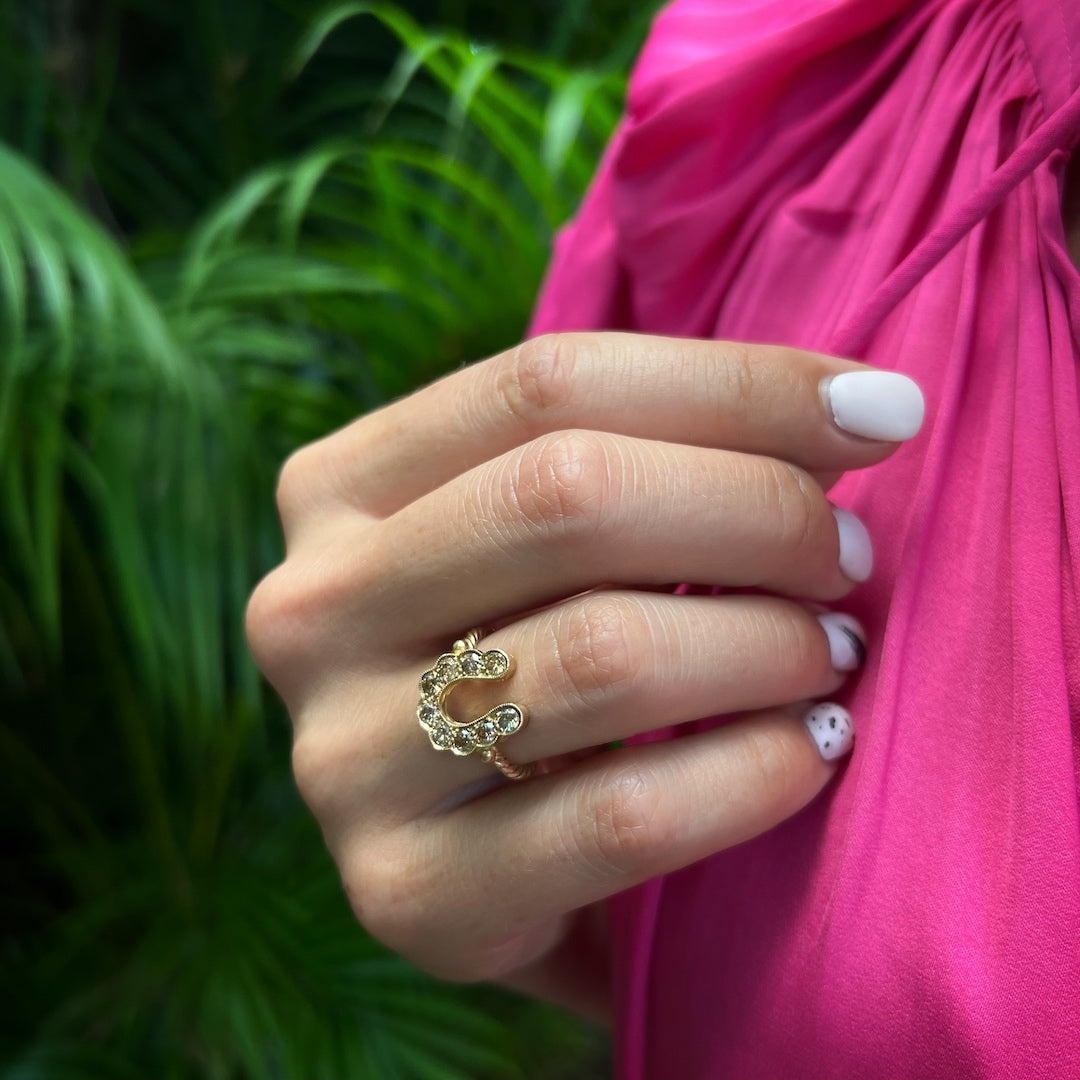Hand Model Wearing Gold and Diamond Horseshoe Ring - Luxurious 14k yellow gold ring adorned with chocolate diamonds, featuring a lucky horseshoe motif.