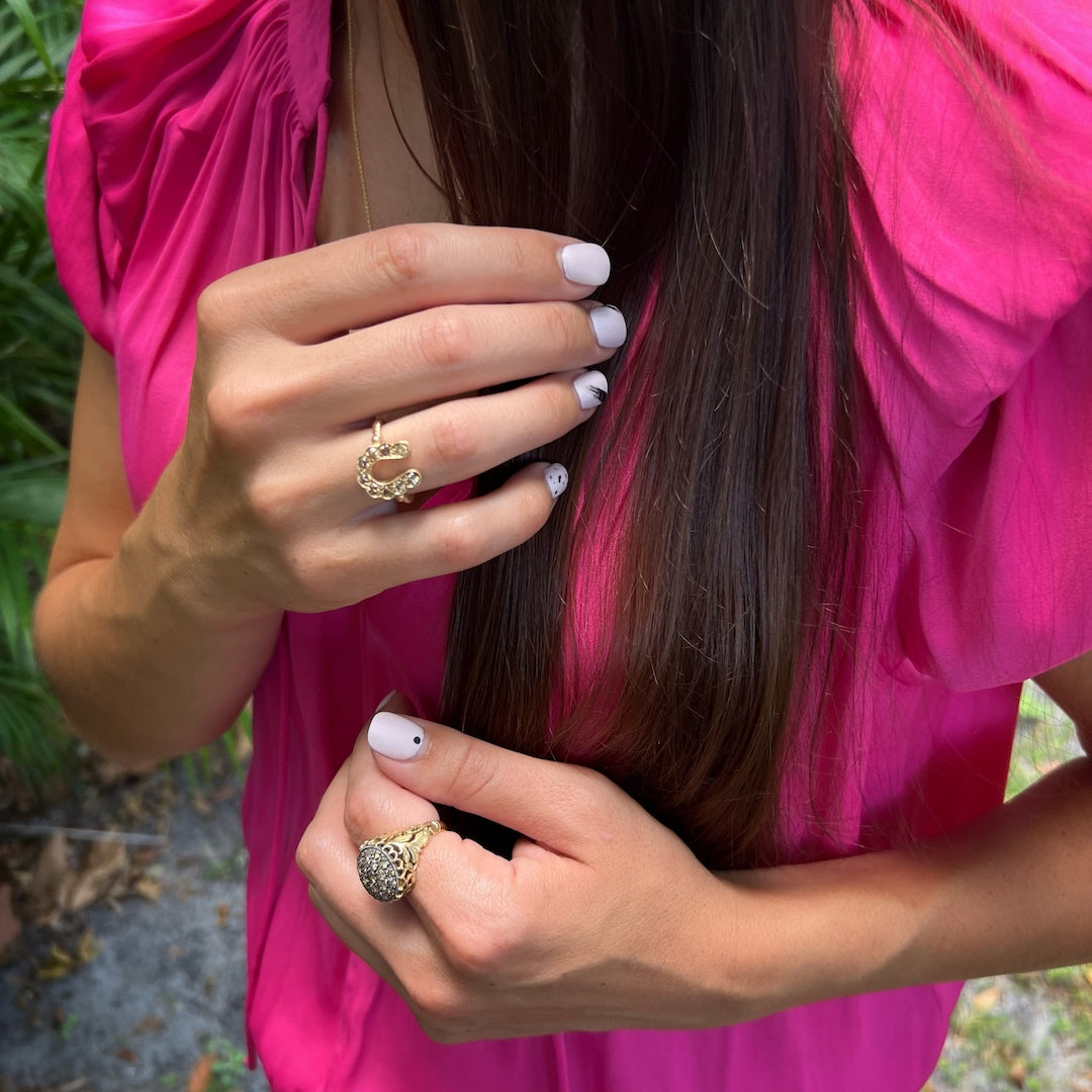 Hand Model Displaying Gold and Diamond Horseshoe Ring - The luxurious appeal of the 14k yellow gold ring with chocolate diamonds is beautifully showcased by a hand model.