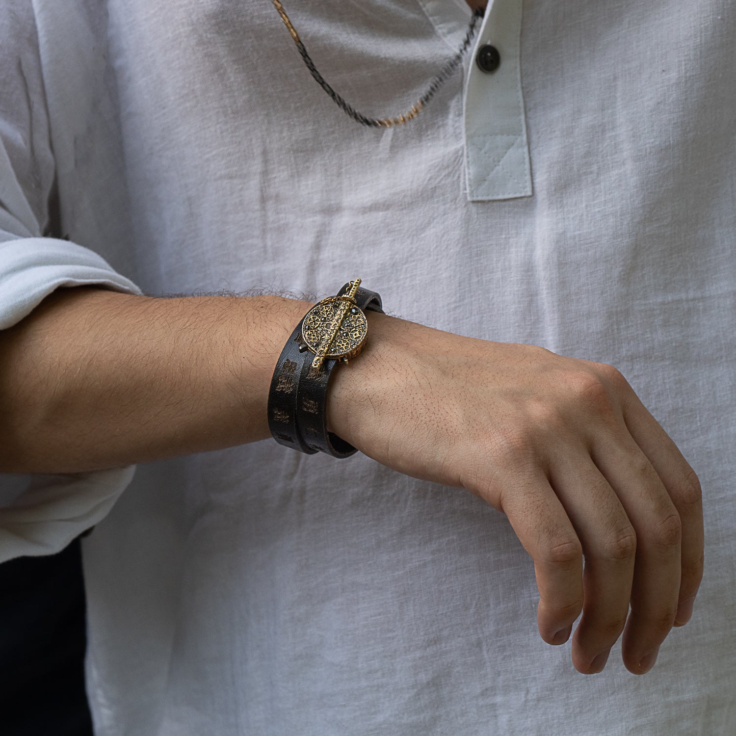 A closer look at the Handmade Gold and Diamond Bushido Bracelet, worn by our model, accentuating its stunning details, luxurious materials, and the intricate engraving on the leather double wrap bracelet.
