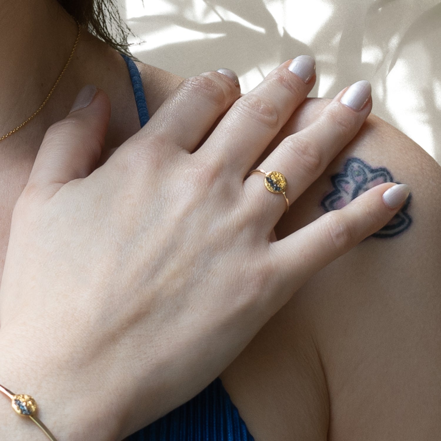 Close-up shot of the Nature Round Gold Diamond Ring on a model's finger, highlighting the intricate design and the brilliance of the diamonds.