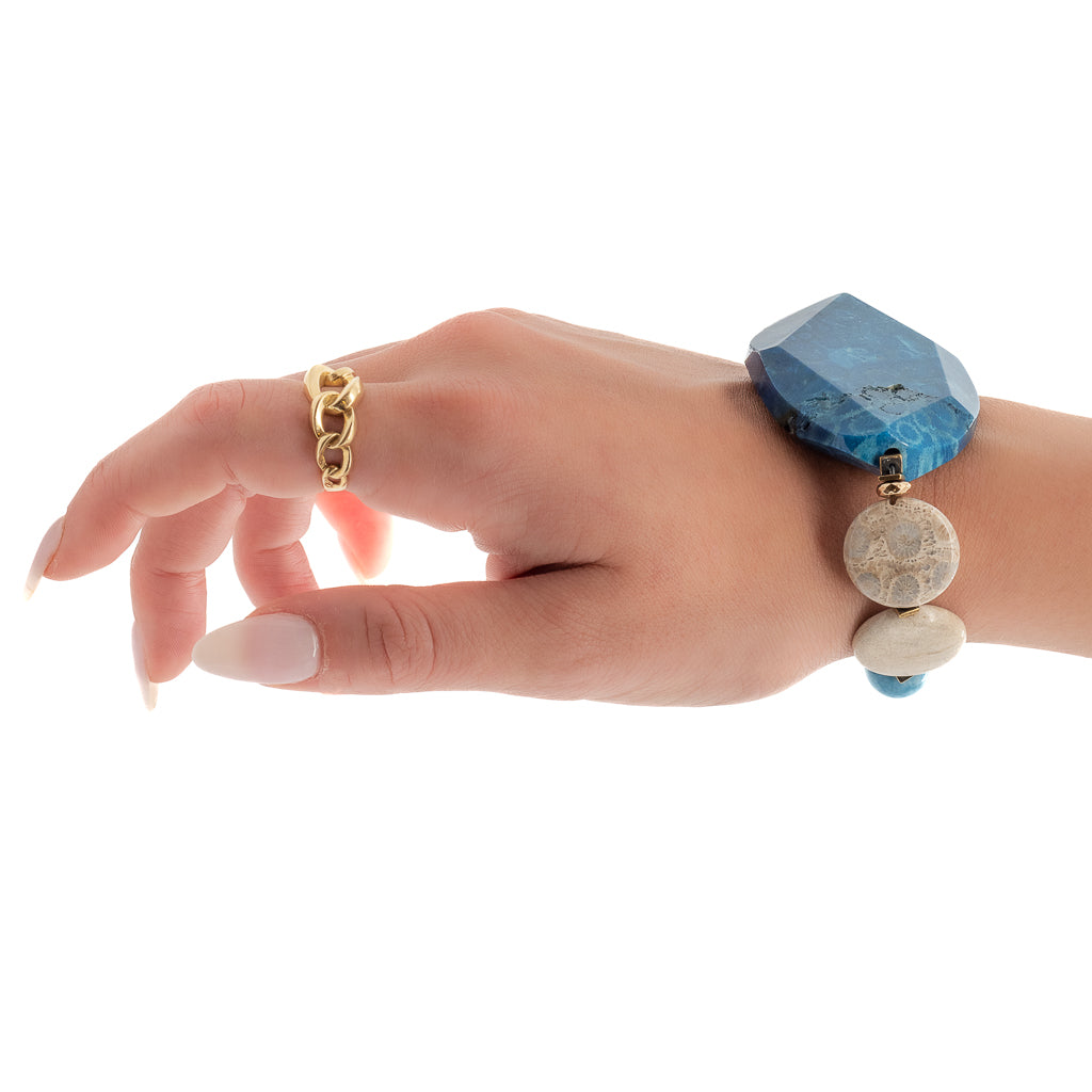 Experience the elegance of the New World Bracelet through the model's hand, highlighting its blue agate gemstone beads and rose gold-plated Swarovski bead.