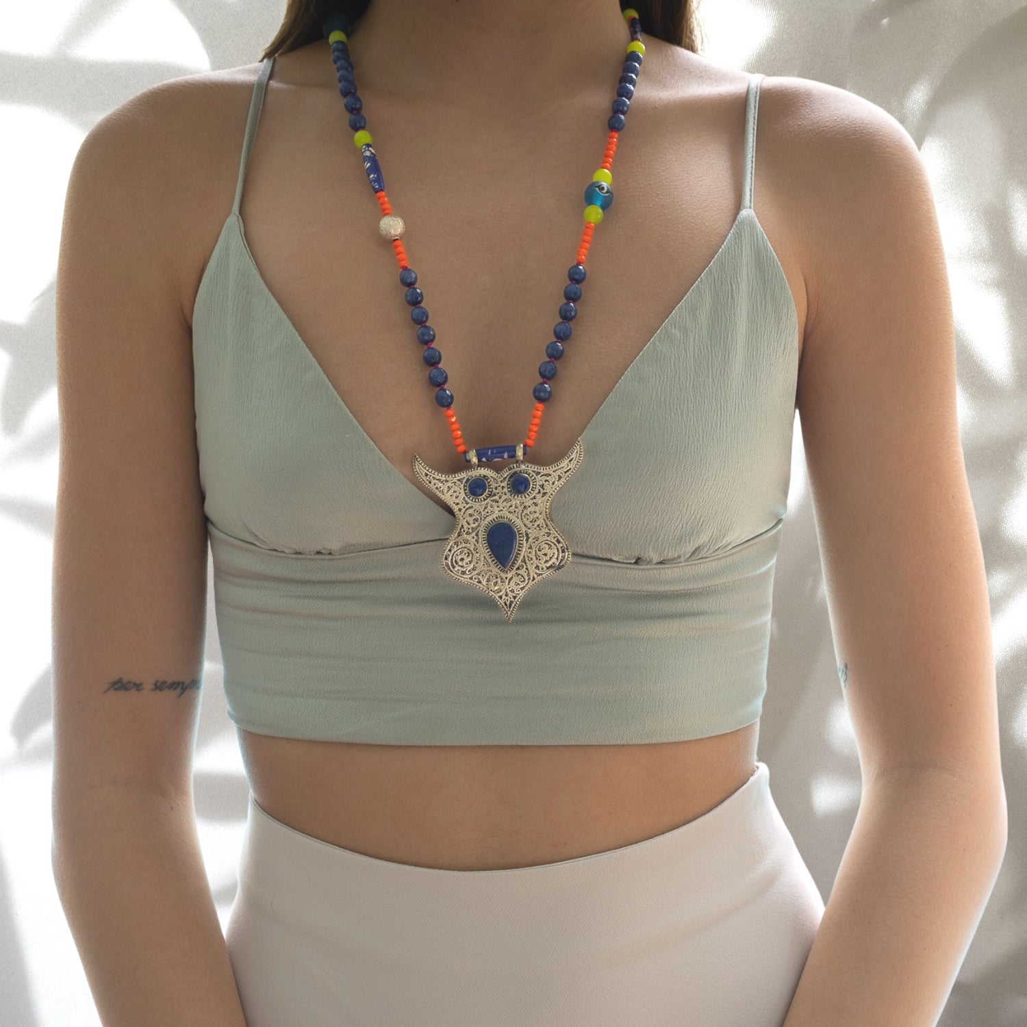 The model radiates elegance while wearing the Night Owl Necklace, showcasing its intricate design and symbolic meaning.