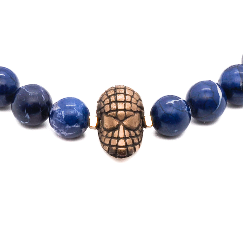 Close-up of Spider Man charm on deep blue jasper bracelet, accented with bronze details.
