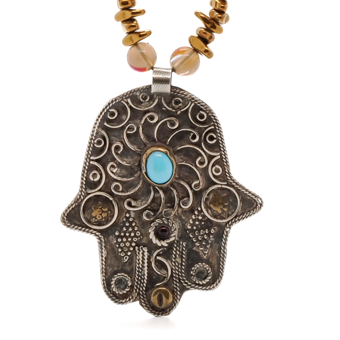 Discover the beauty and meaning of the Turtle Necklace, adorned with white howlite, cat eye, and coral beads.