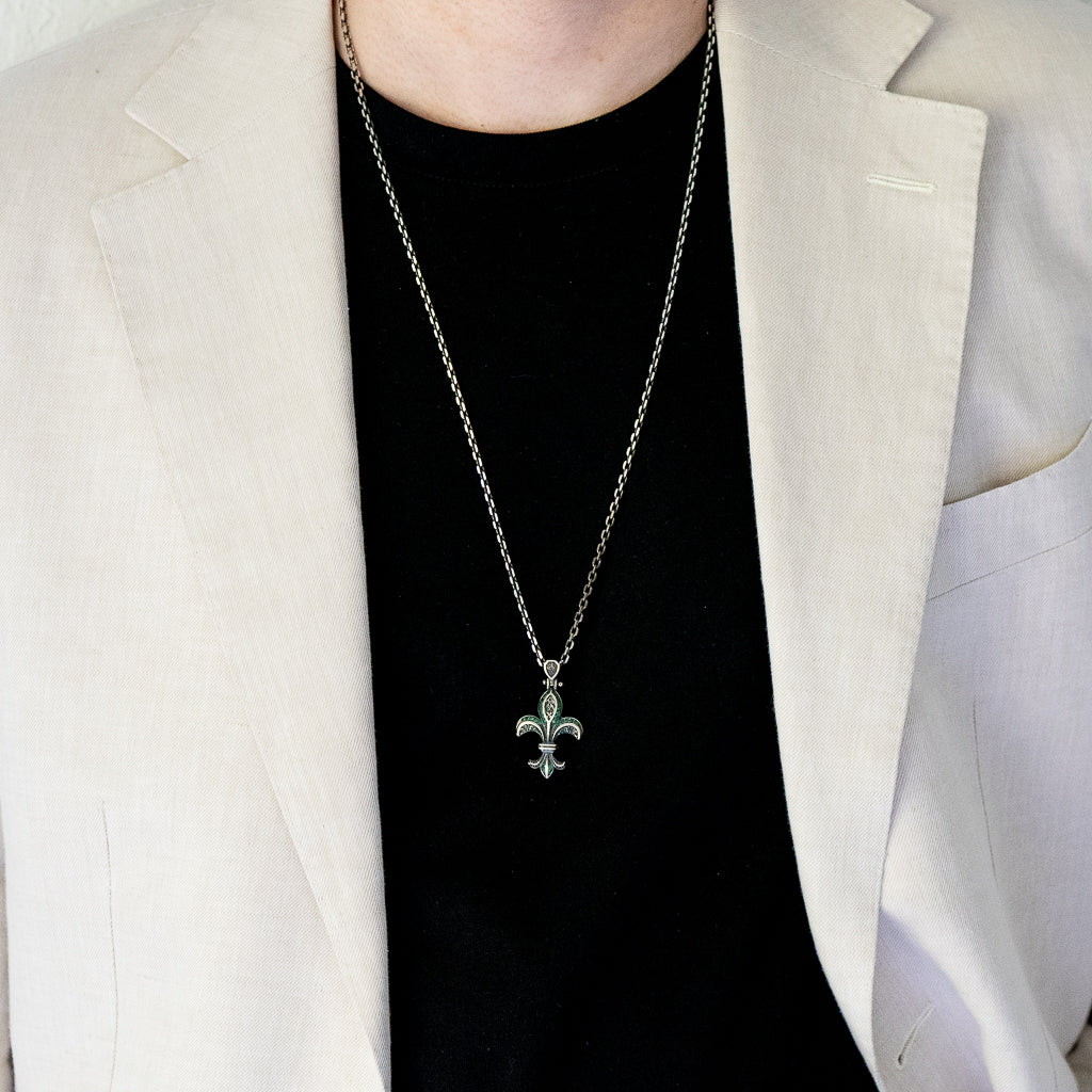 The Unique Designer Fleur de Lis Necklace beautifully adorns the model, adding a touch of sophistication and individuality to their look.