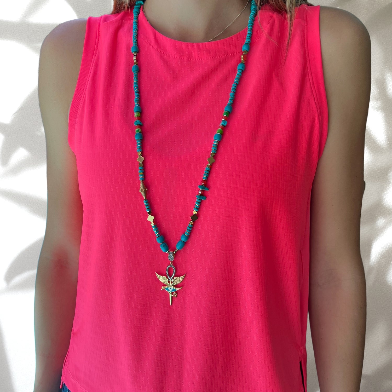 The eye-catching design of the Unique Eye of Horus Turquoise Necklace perfectly complementing the model's outfit