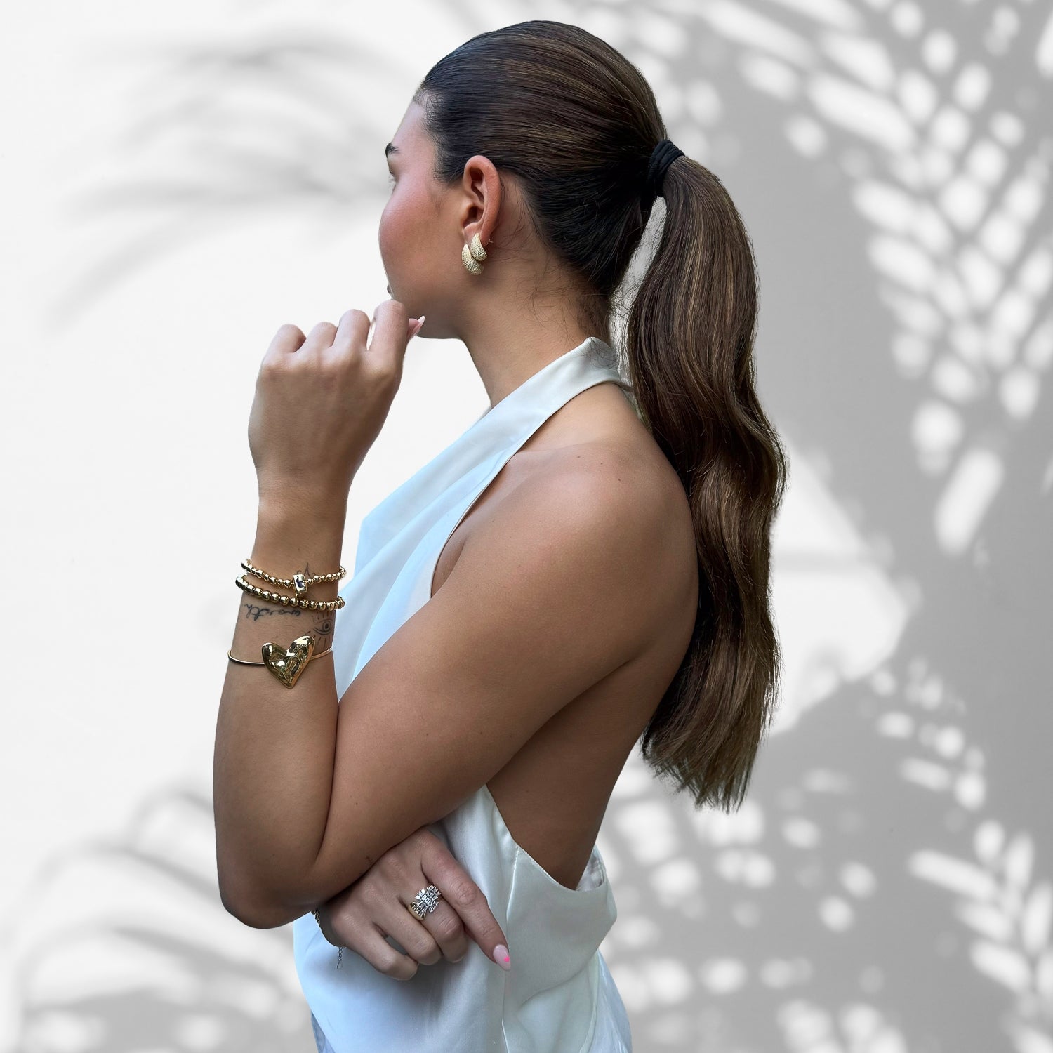 Model Wearing a Bold Elegance Necklace: Heart-Shaped Centerpiece on Gold Cuff Bracelet