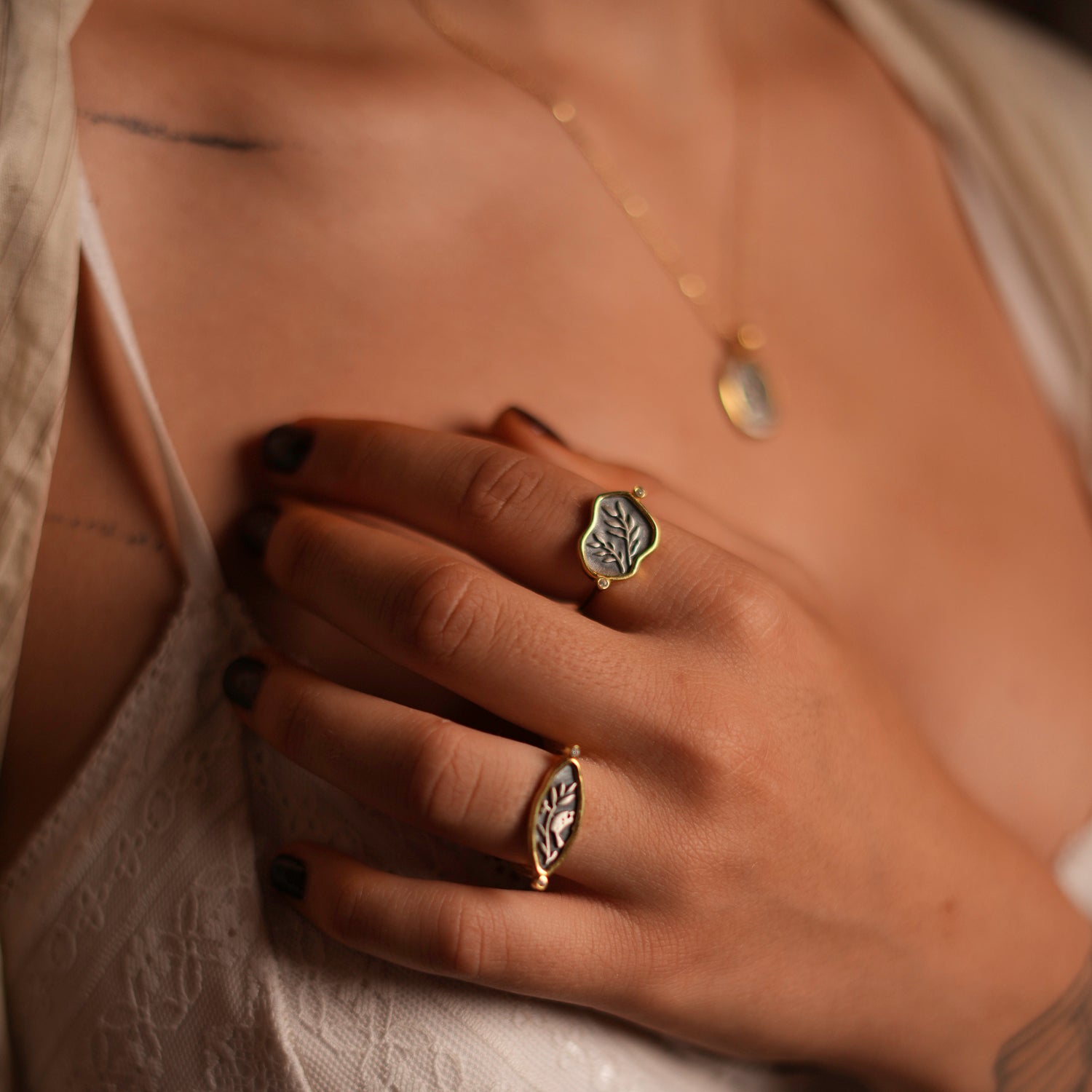 Graceful sterling silver signet ring with teardrop shape, featuring olive leaf and bird engravings, complemented by 18k gold plating