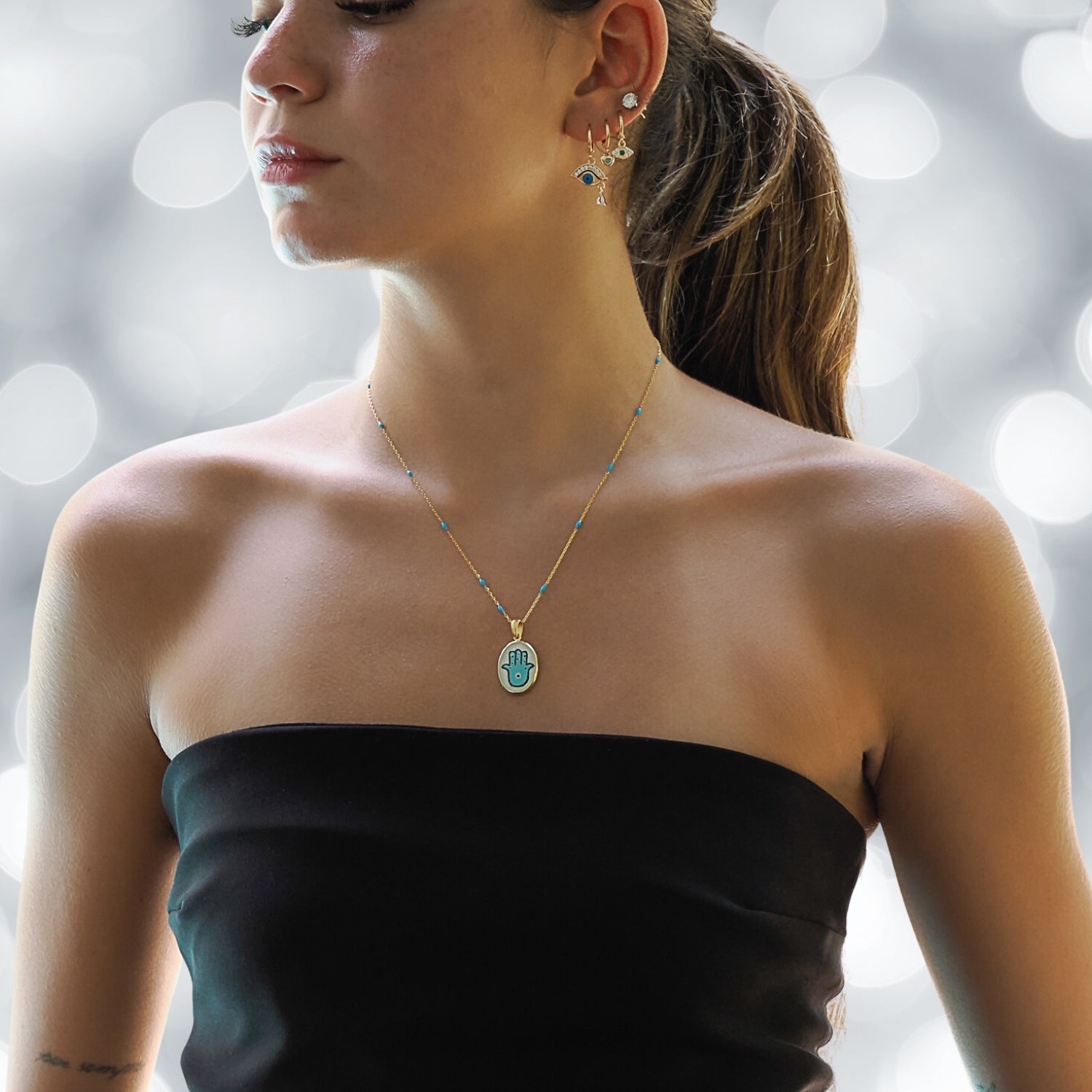 Model Wearing a Sterling Silver and Gold Hamsa Hand Necklace - Embodying Protection and Style.