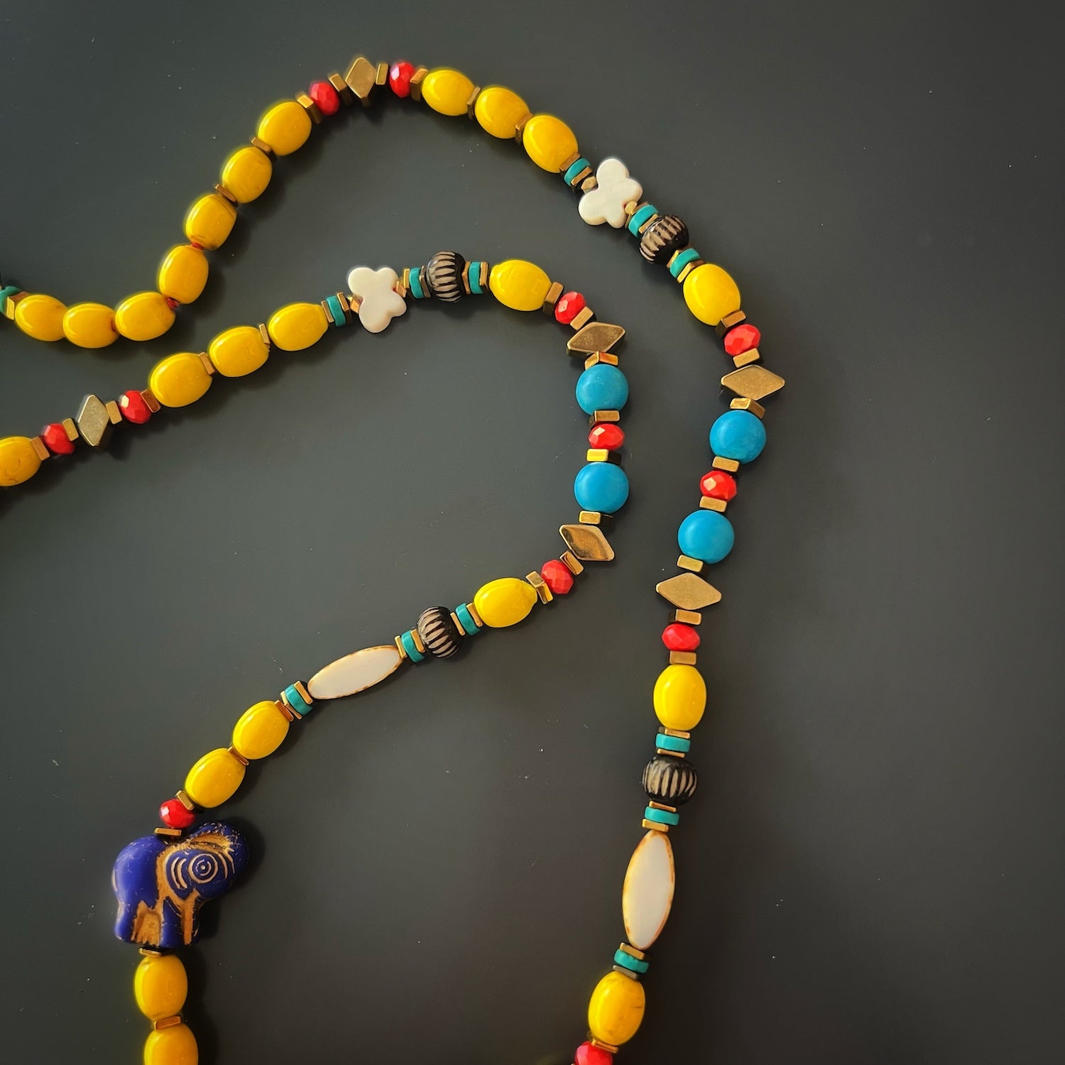 Necklace with turquoise stone beads, African beads, pearl butterfly beads, and an Evil Eye pendant.