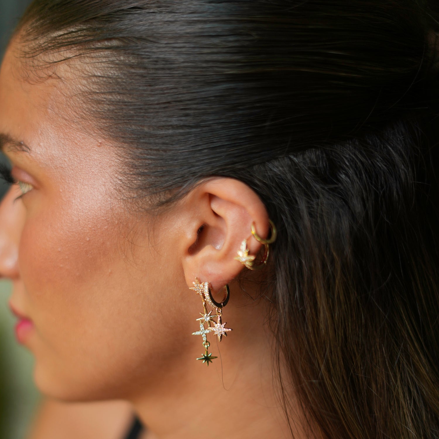 Versatile earring set with three gold star charms and CZ diamonds, designed for a cosmic elegance