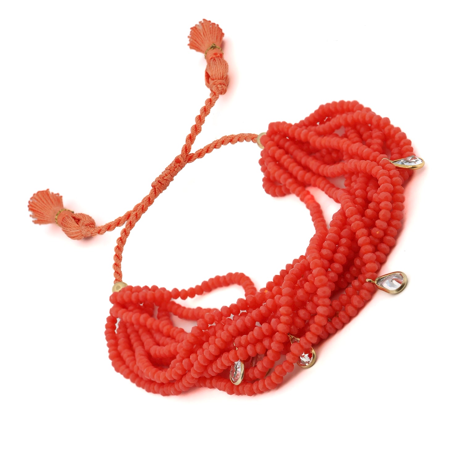 Adjustable multi-strand bracelet with bright orange crystal beads, silver accents, and bohemian tassels