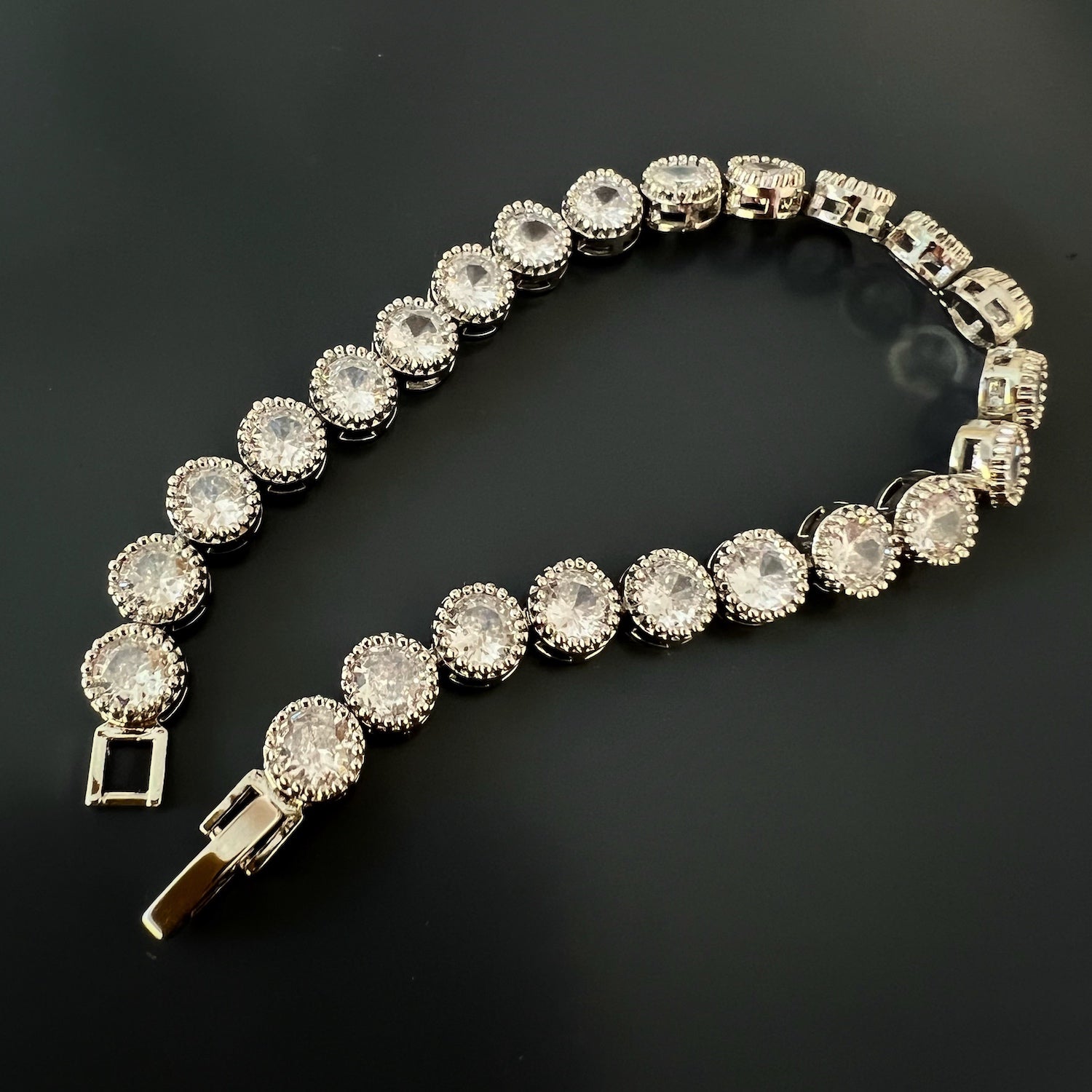 Top view of the vintage-style Diamond Tennis Bracelet, featuring a line of brilliant diamonds set in a delicate silver on brass band.