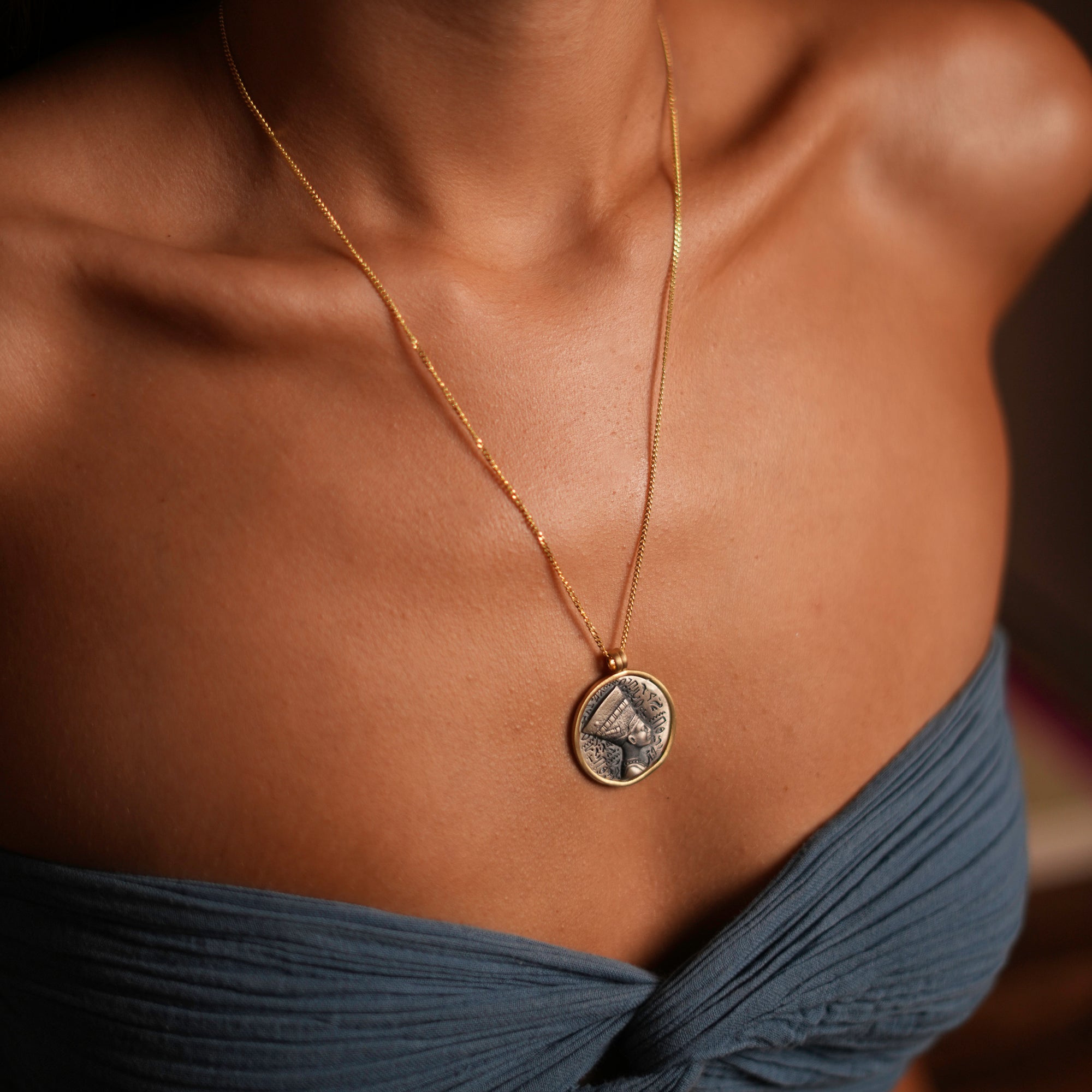 Elegant necklace with a sterling silver pendant of Queen Nefertiti, surrounded by gold plating, representing beauty and spiritual connection.