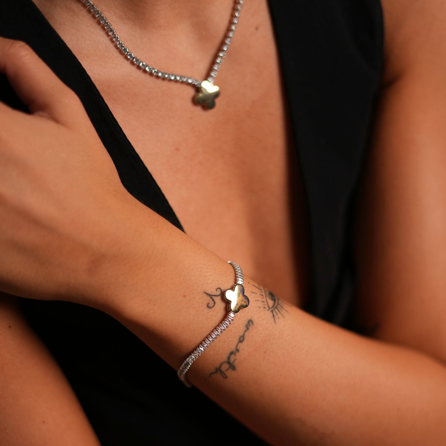 Delicate gold-plated bracelet with a clover charm and baguette-style diamonds, adjustable size