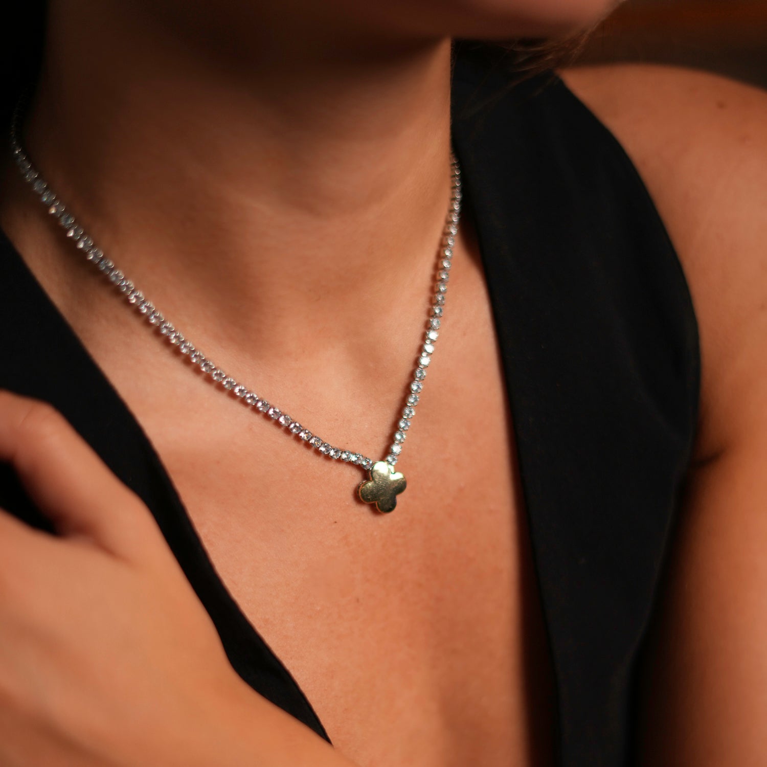 Cubic zirconia diamond tennis necklace with a gold clover charm, adjustable length