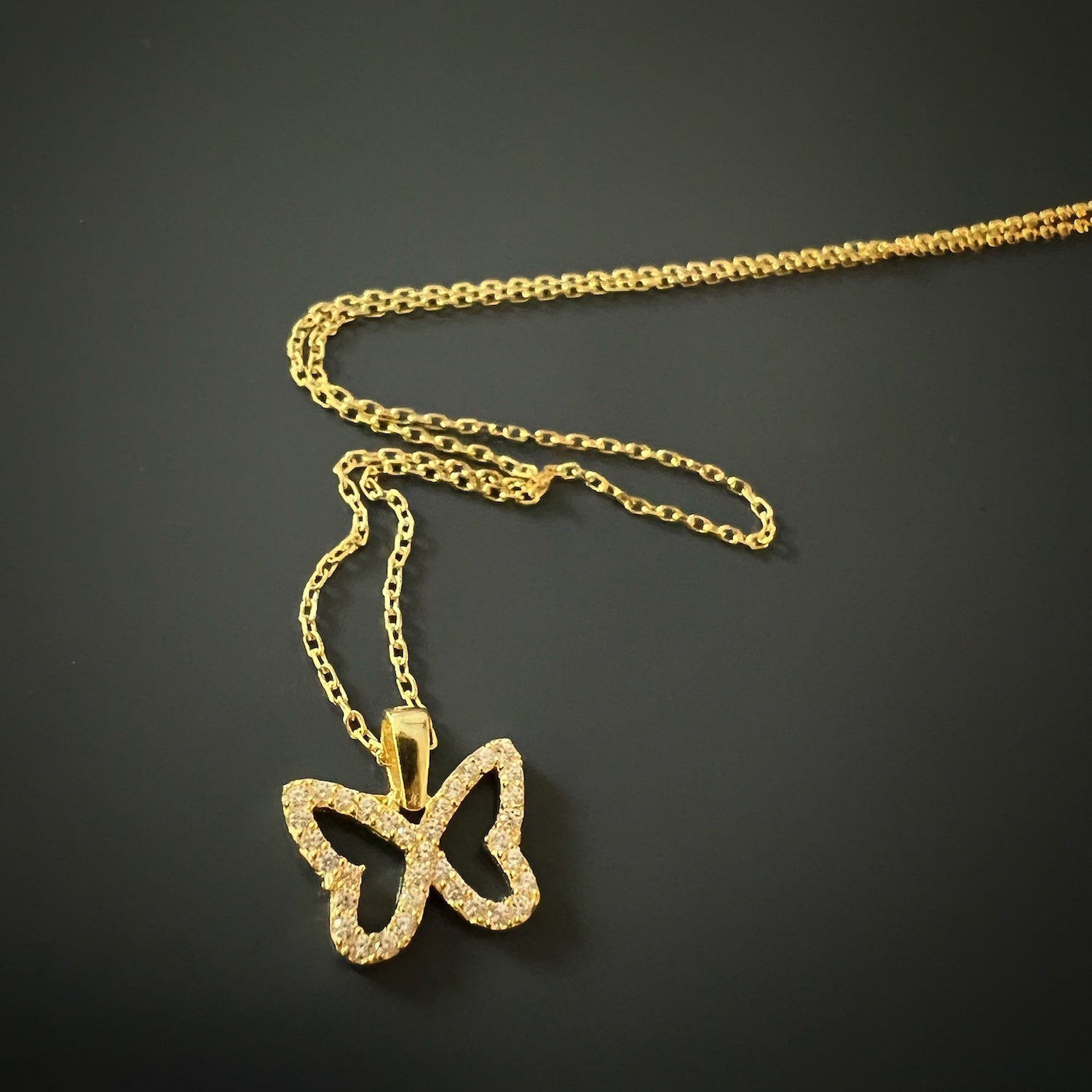 The captivating Gold Sparkly Butterfly Necklace, a stylish accessory with a touch of luxury.