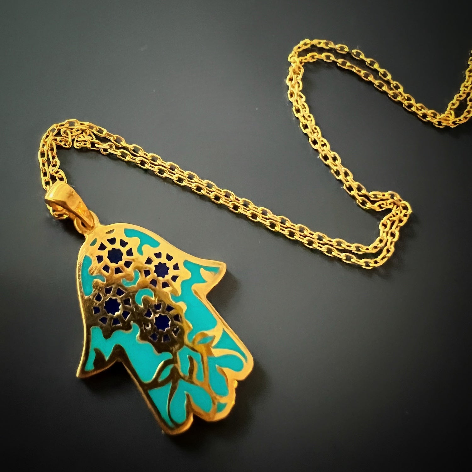 A detailed shot of the beautifully crafted Hamsa pendant on the Good Vibes Enamel Hamsa Necklace.