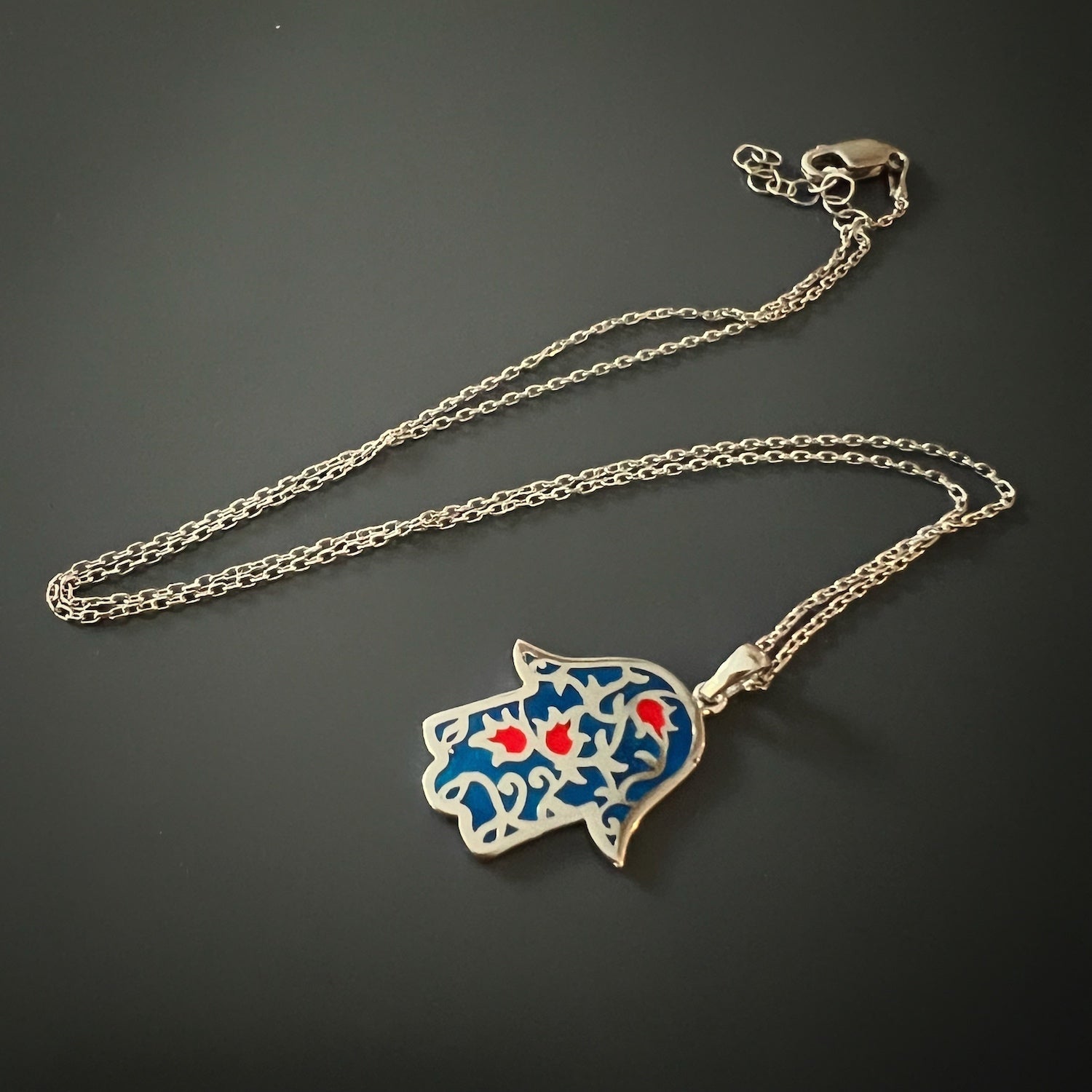 The Hamsa pendant, symbolizing protection and good vibes, on the Good Vibes Enamel Hamsa Necklace Silver.