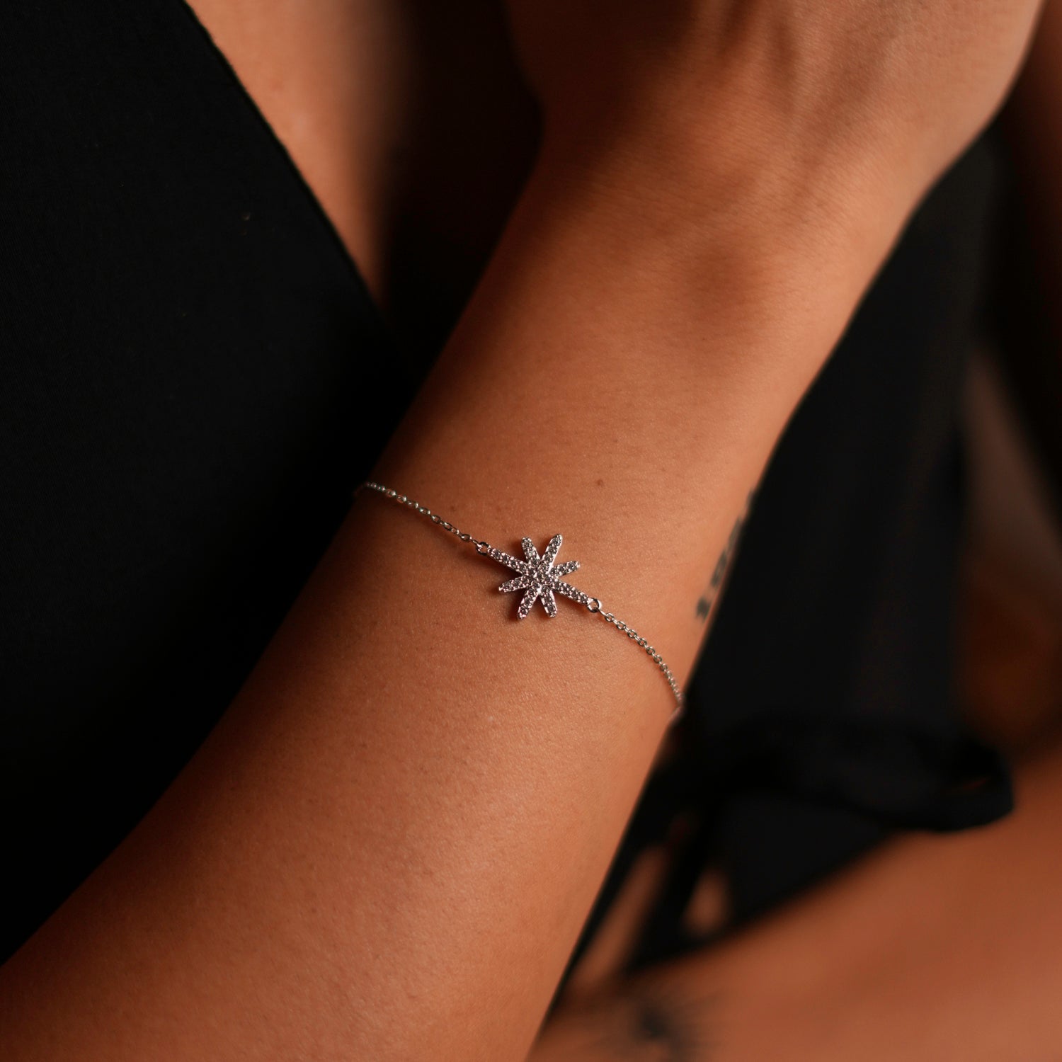 Sterling silver bracelet with a guidance star charm and CZ diamond accents, adjustable length for versatility.
