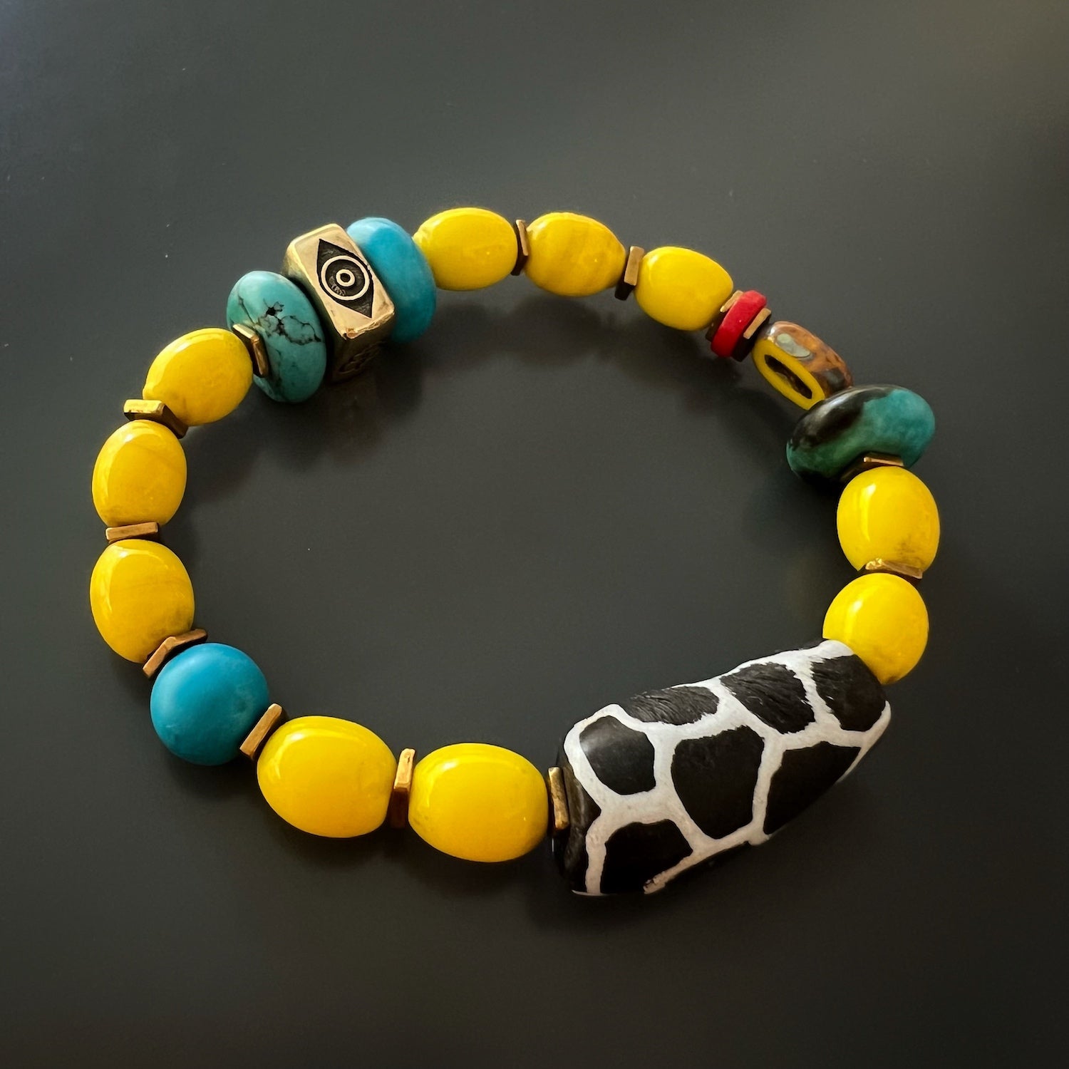 the Happiness Symbol Yellow Bracelet, highlighting the stretchy jewelry cord and the high-quality craftsmanship of the handmade piece, emphasizing its durability and comfortable fit.