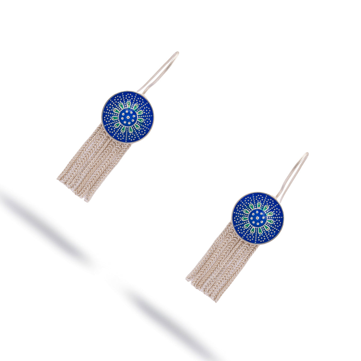 The tassel earrings at an angle, showing the woven silver chain strands below each enamel medallion