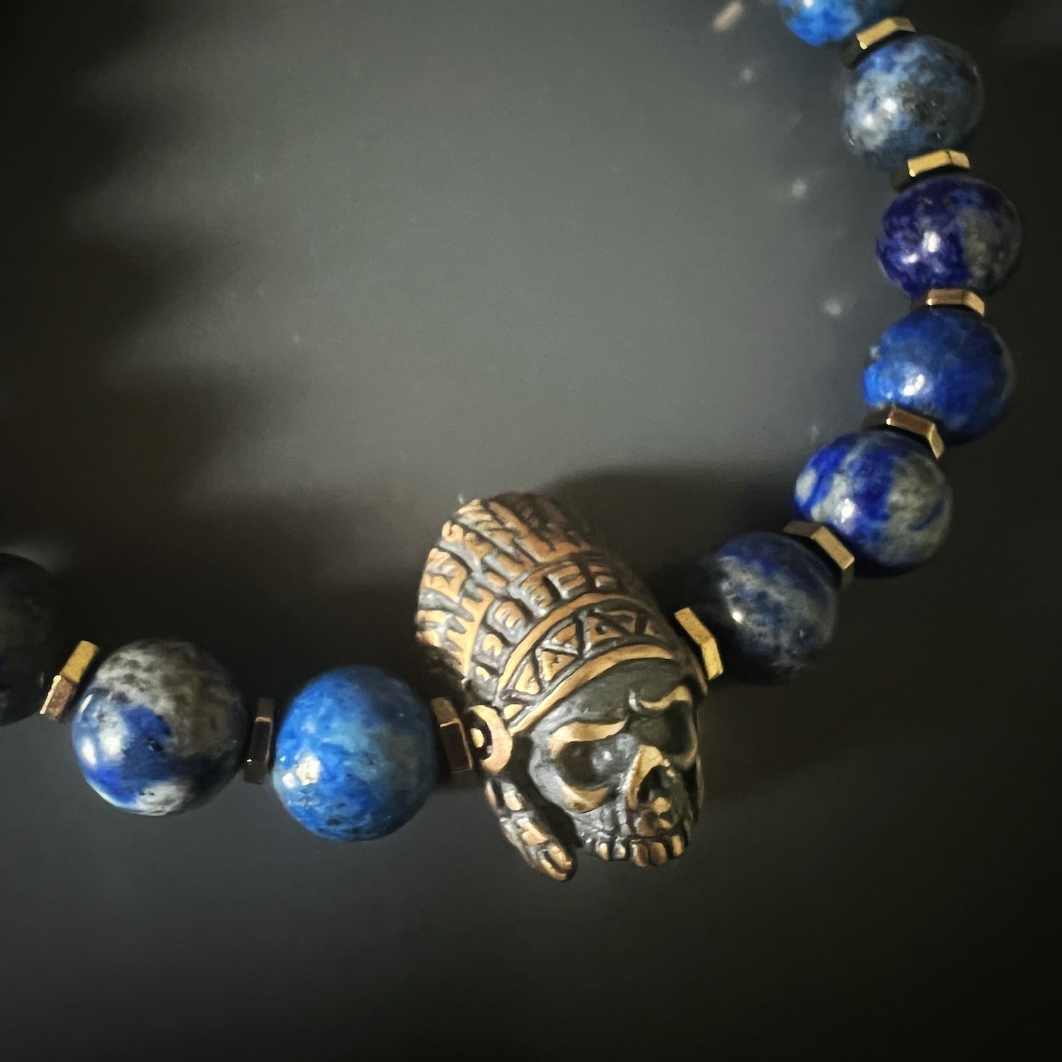 Lapis Lazuli bracelet with gold hematite spacers, bronze Indian Chief charm, and 18K gold-plated logo bead