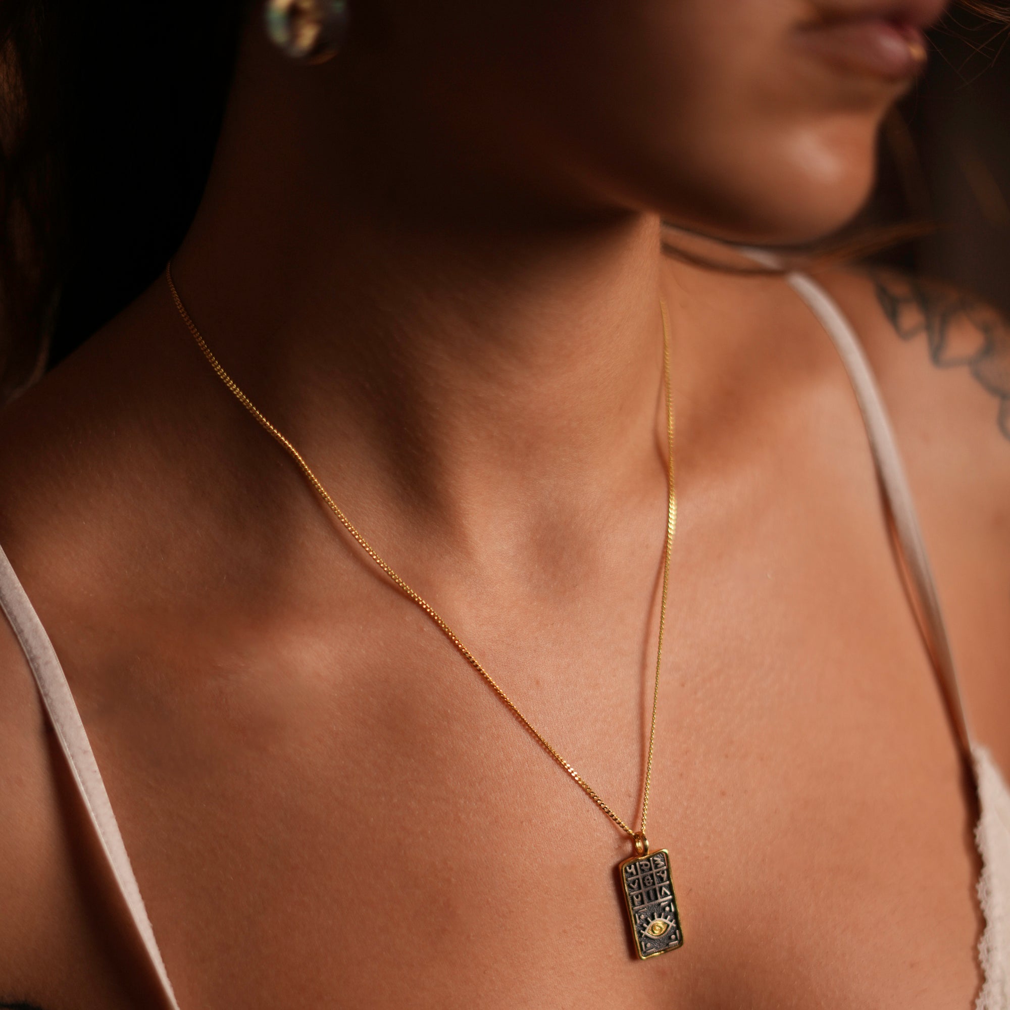 Sterling silver and gold-plated necklace featuring a pendant with engraved magical numbers and a striking evil eye, combining luxury with protective energy.