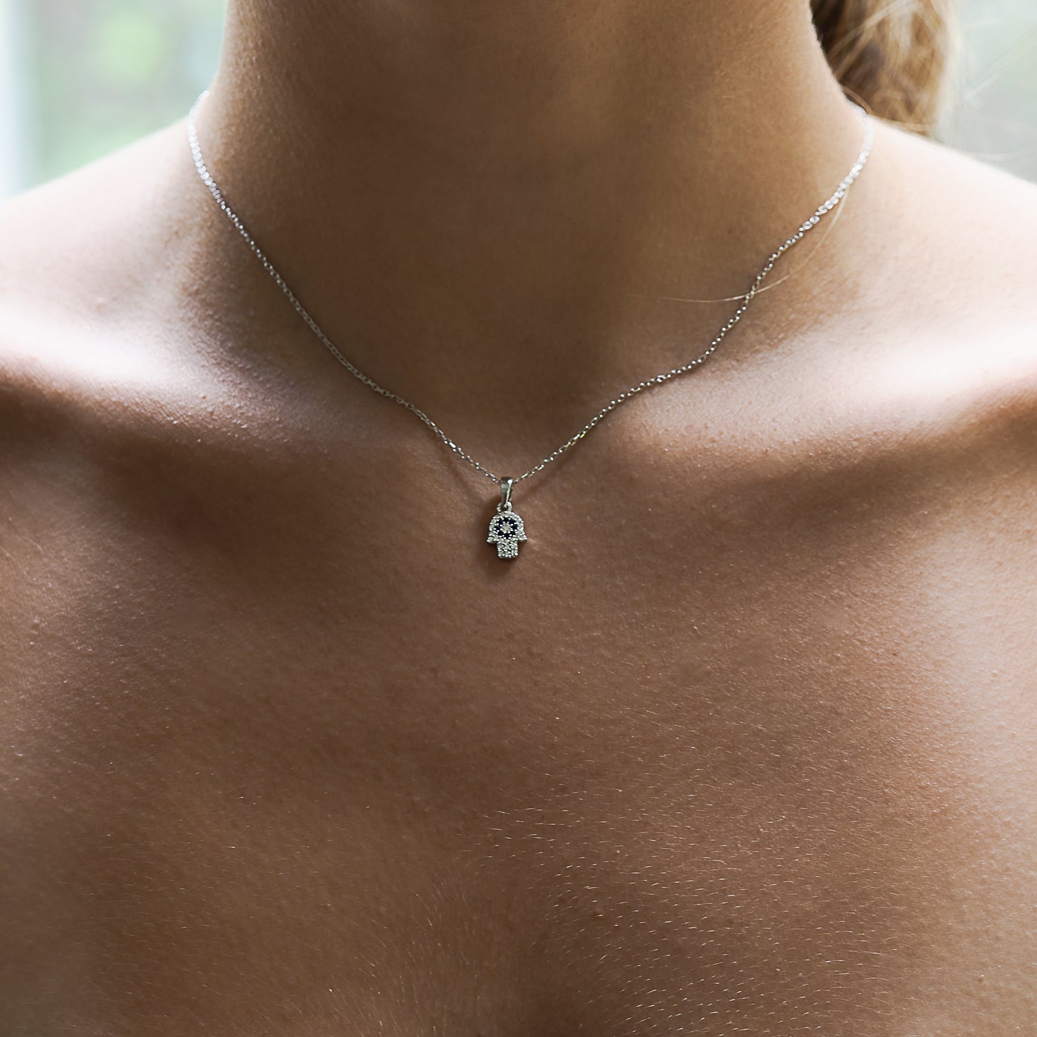 Hamsa Hand Necklace with Zircon Stones on a Graceful Model - Beauty and Meaning Combined.