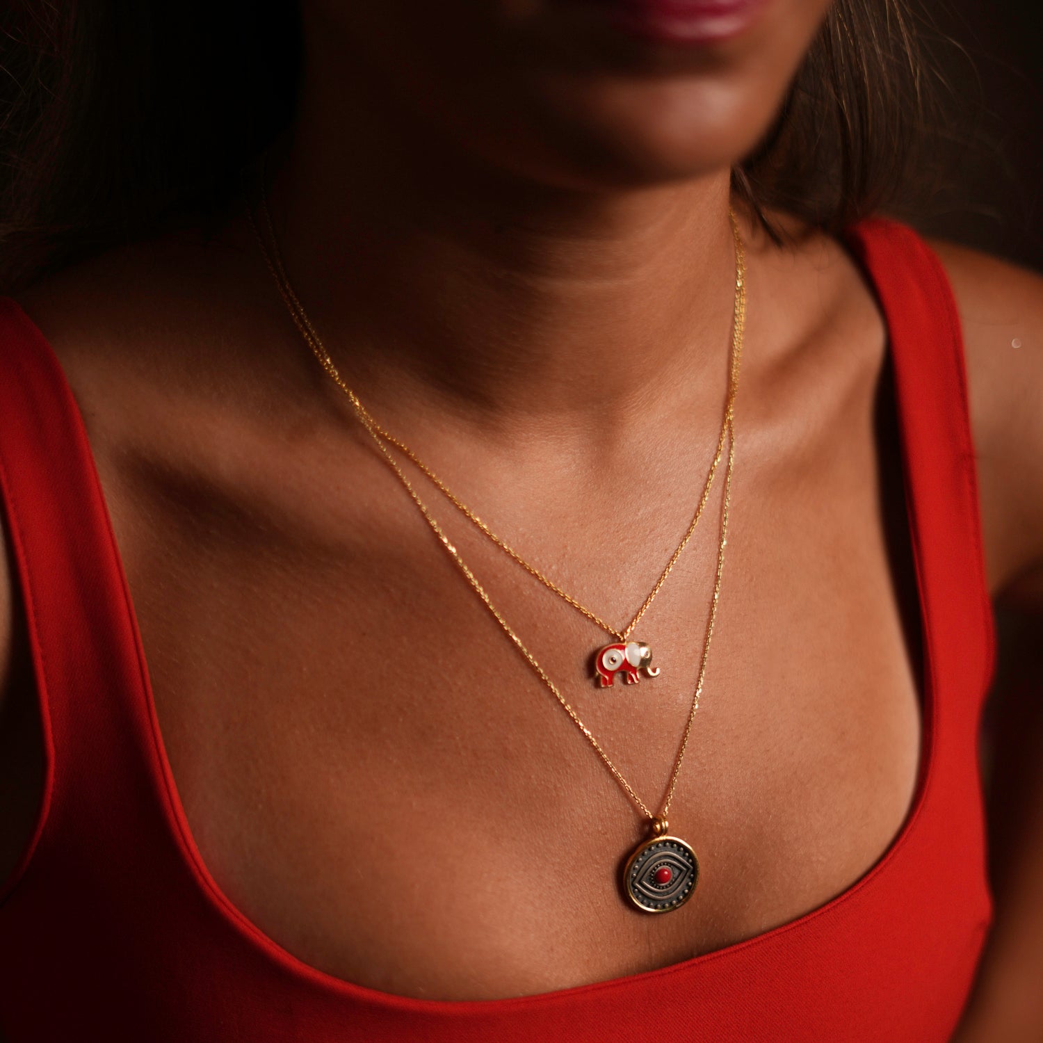 Sophisticated necklace with a red coral evil eye set in a sterling silver pendant and gold vermeil border, designed for vibrant energy and protection.