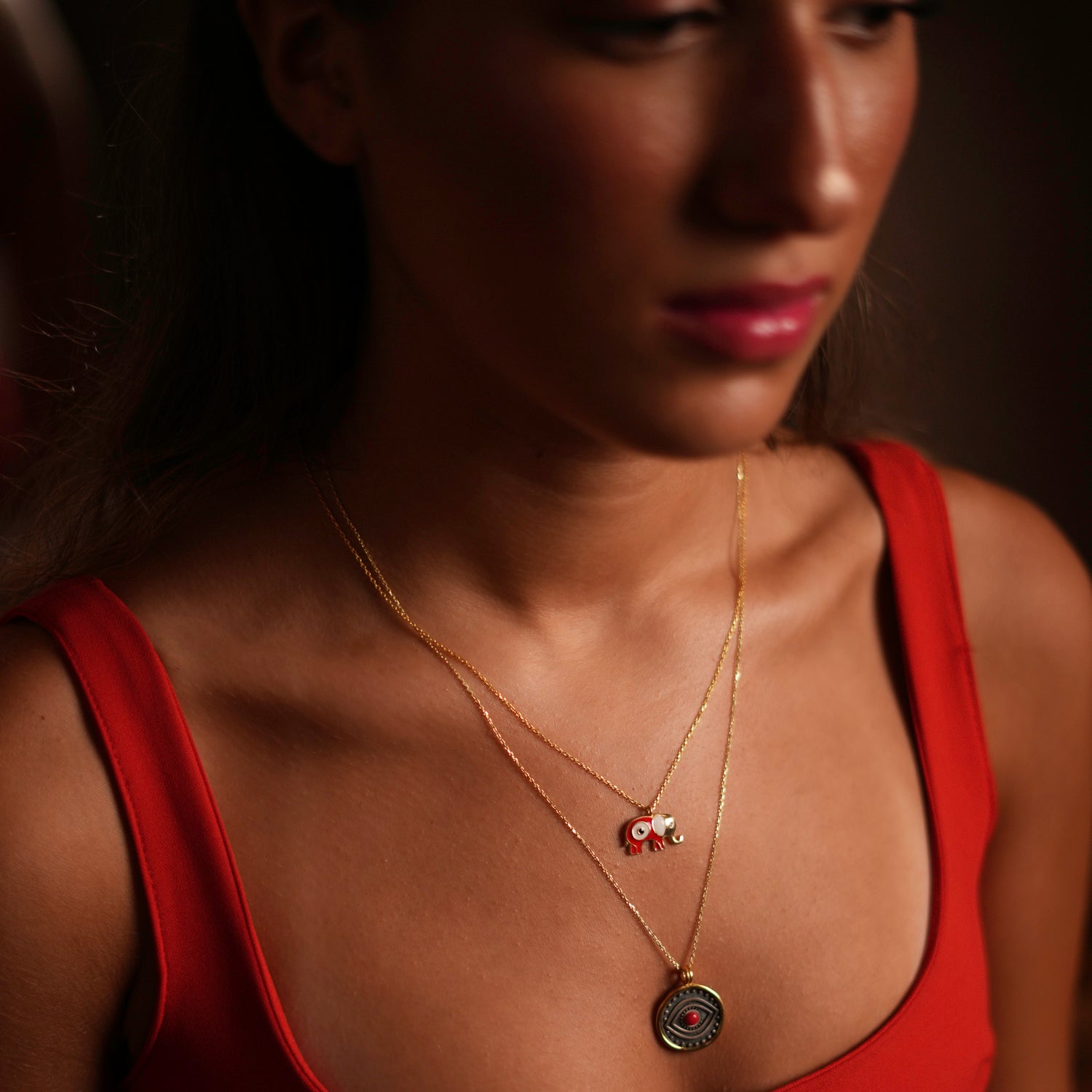 Elegant necklace with a round sterling silver pendant, featuring a red coral evil eye and gold vermeil border, symbolizing passion and protection.