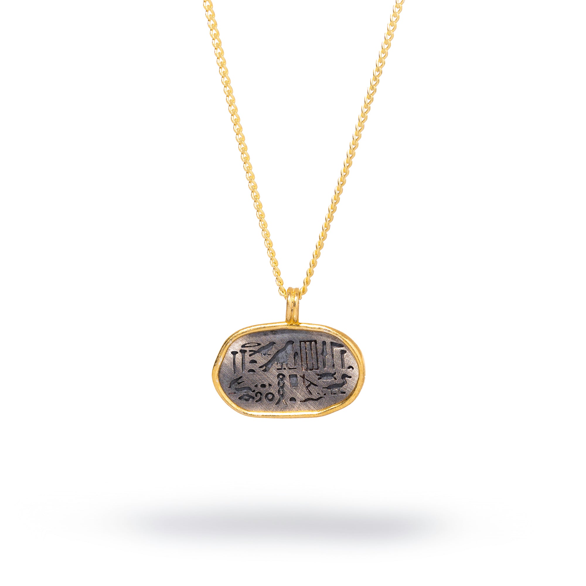 Dainty oval pendant necklace with Egyptian symbols in sterling silver and 18k gold plating, offering spiritual protection.