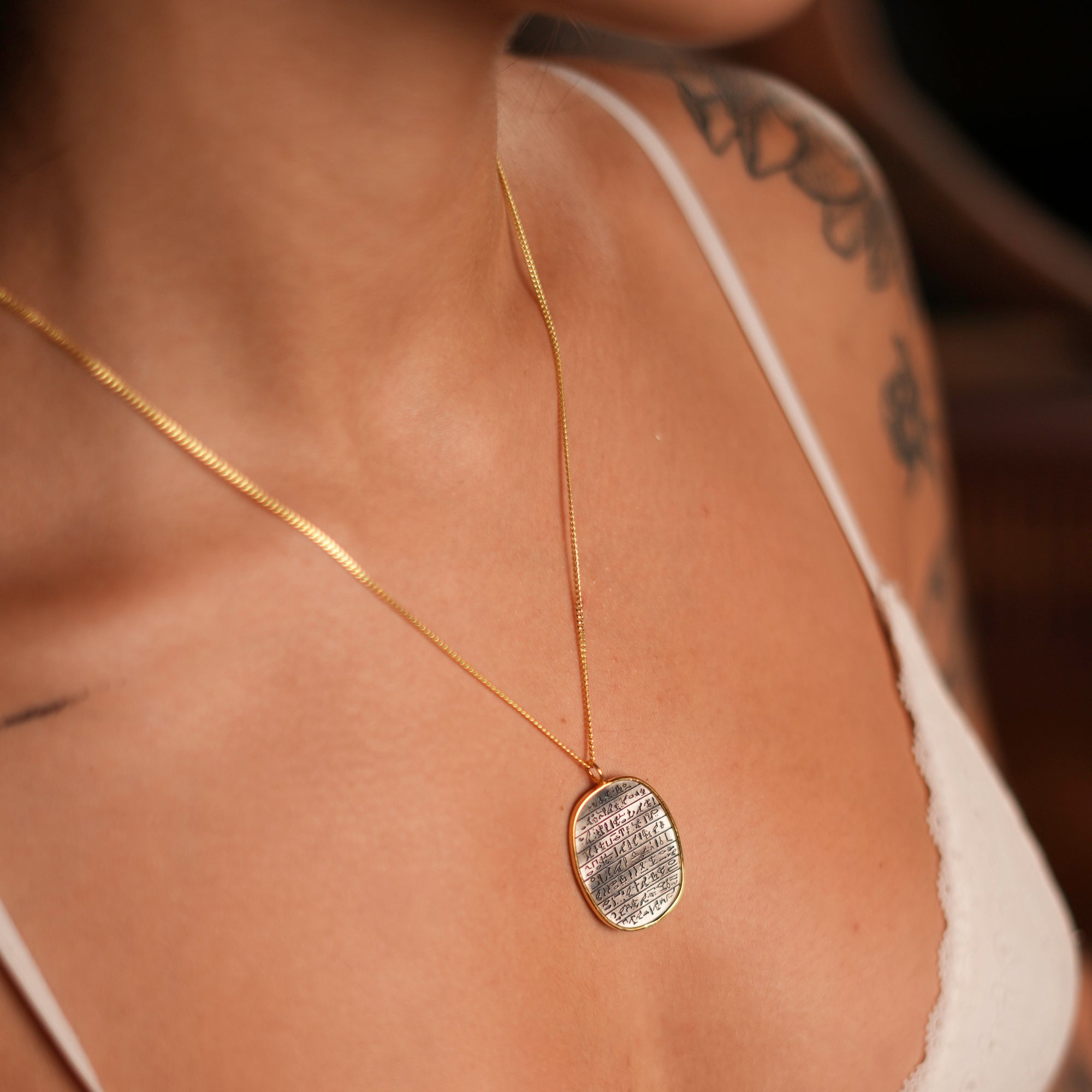 Silver medallion with Egyptian symbols on a gold chain, designed for spiritual empowerment and elegance.